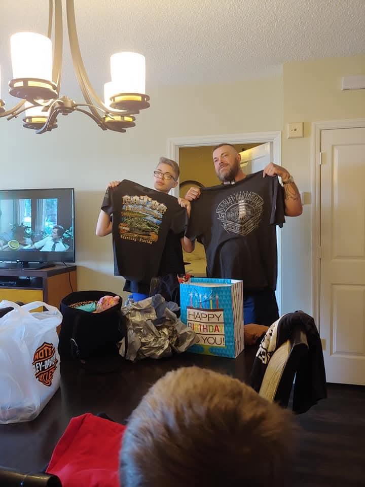 Two men holding up shirts