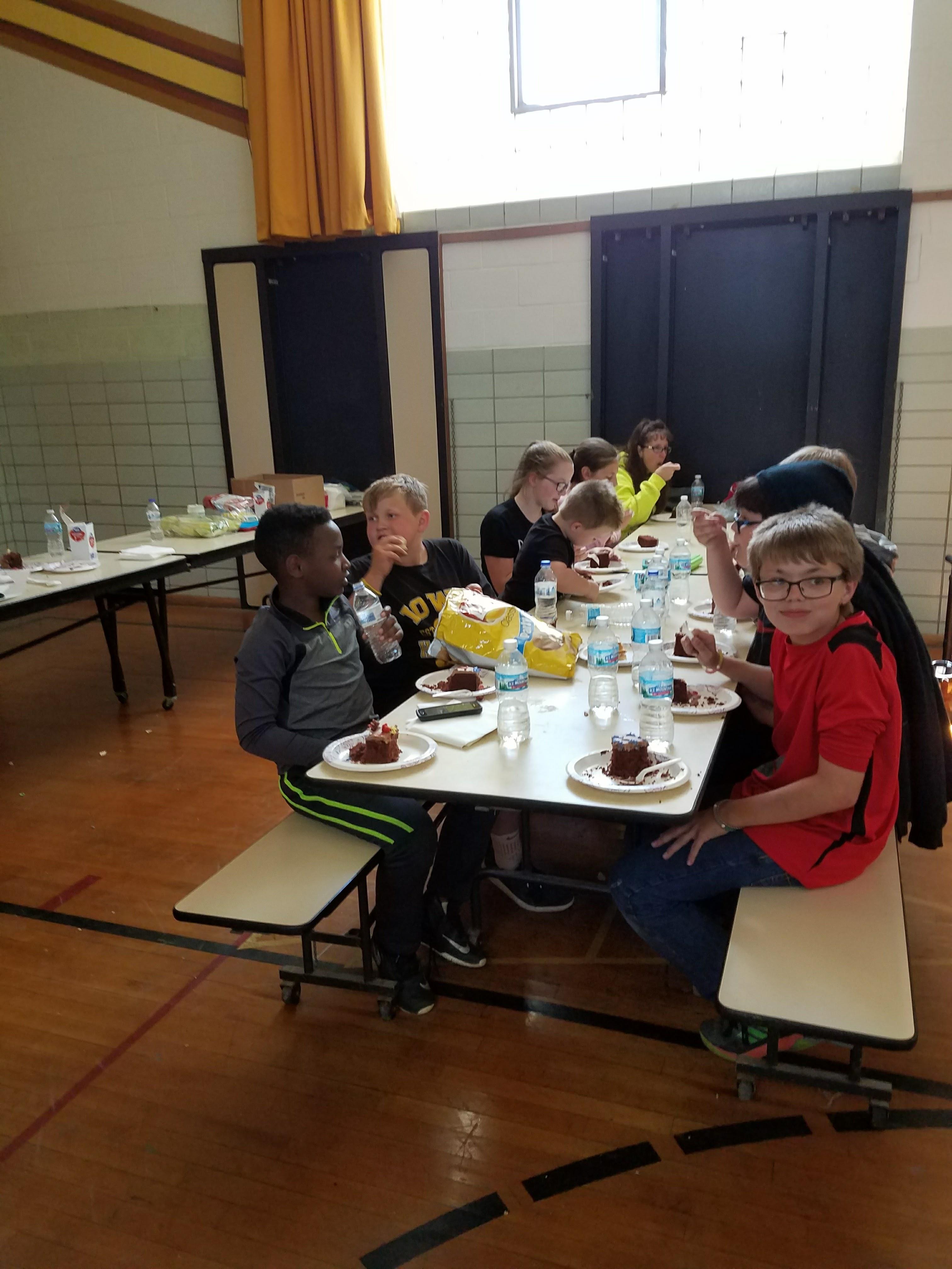 A group of kids sitting at a table eating