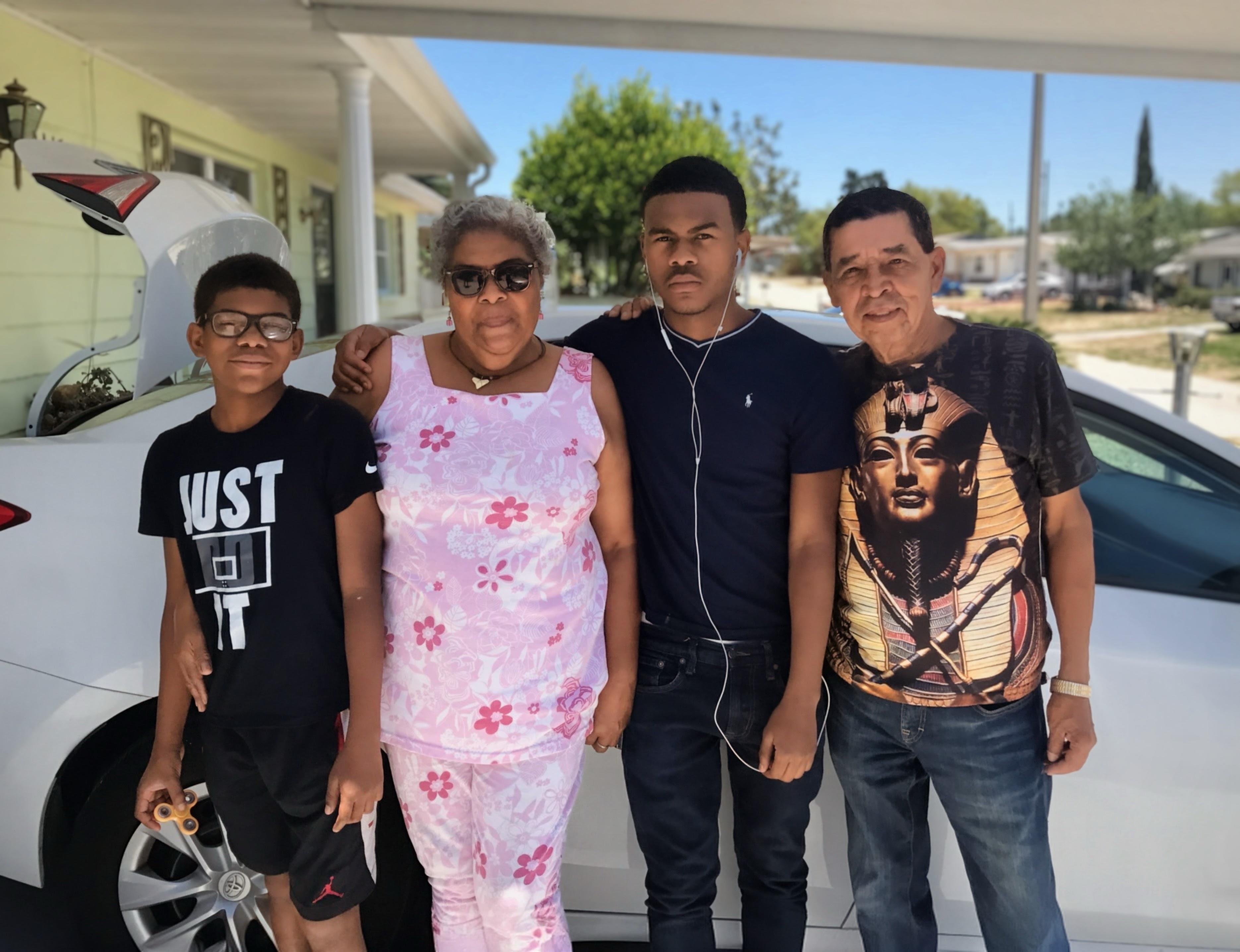 A group of people standing in front of a car
