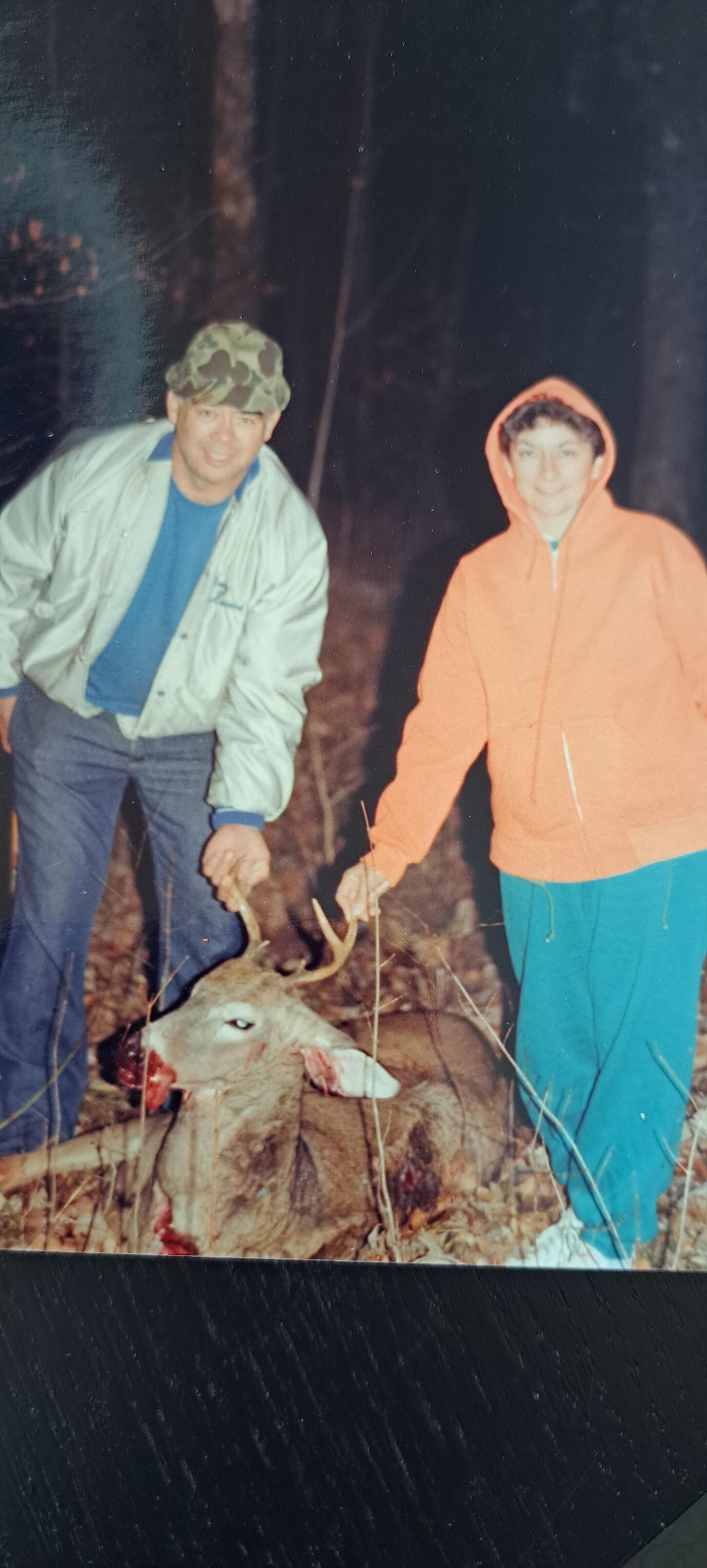 A man and woman holding a deer