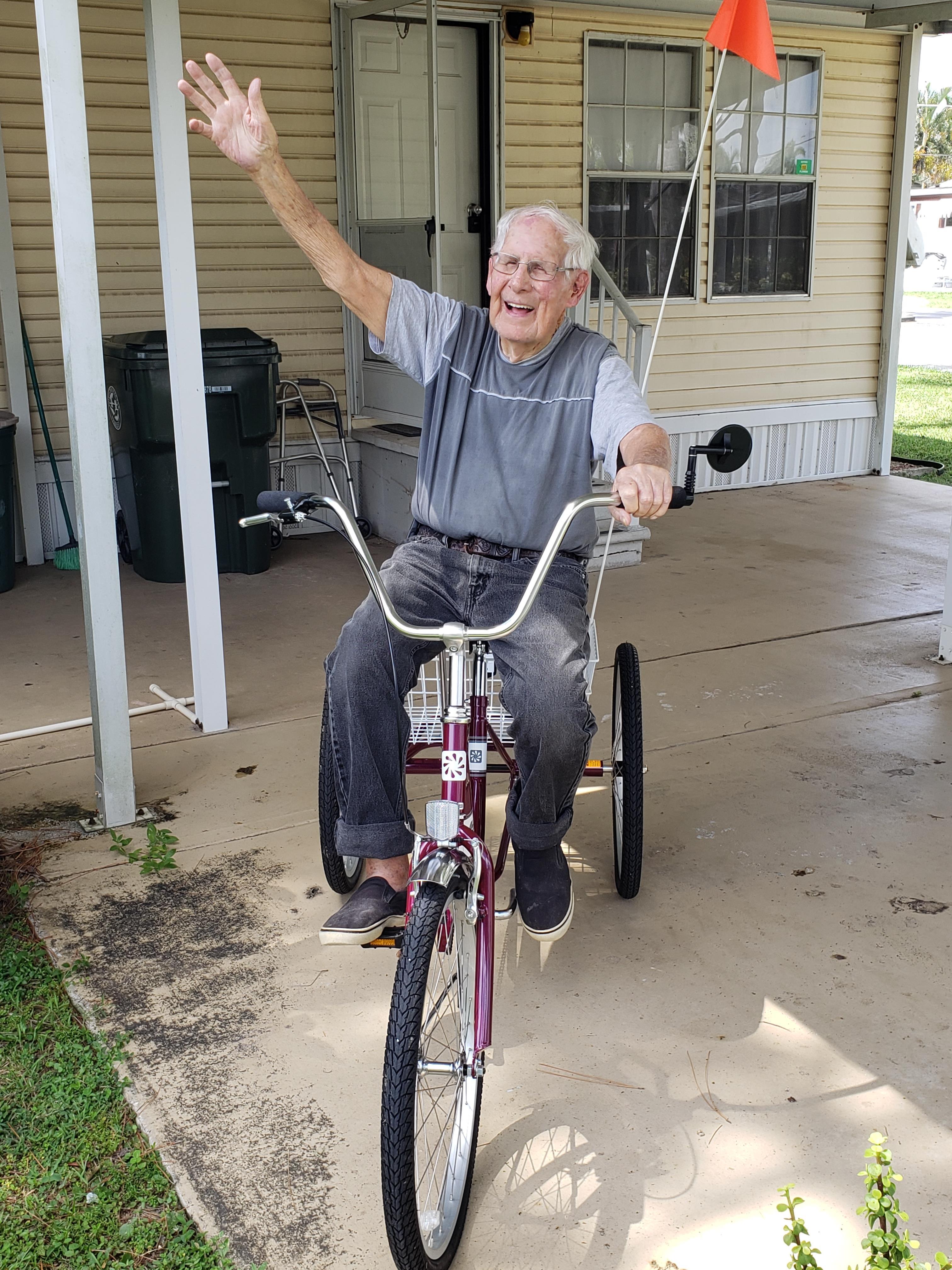 An older man riding a tricycle