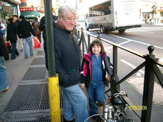 A man and a girl standing on a sidewalk