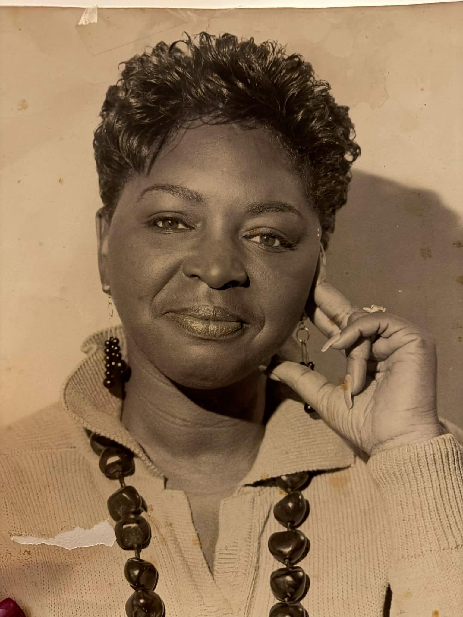 A woman with short hair wearing a necklace and a necklace