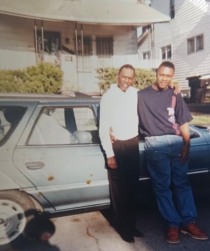 Two men standing next to a car