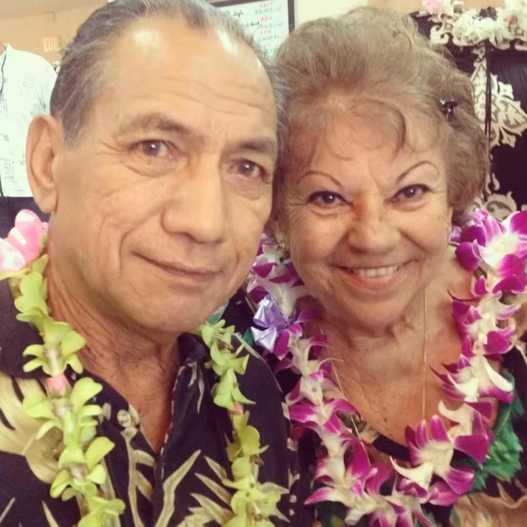 Couple takes a selfie while celebrating a special occasion in Hawaii with leis around their necks.