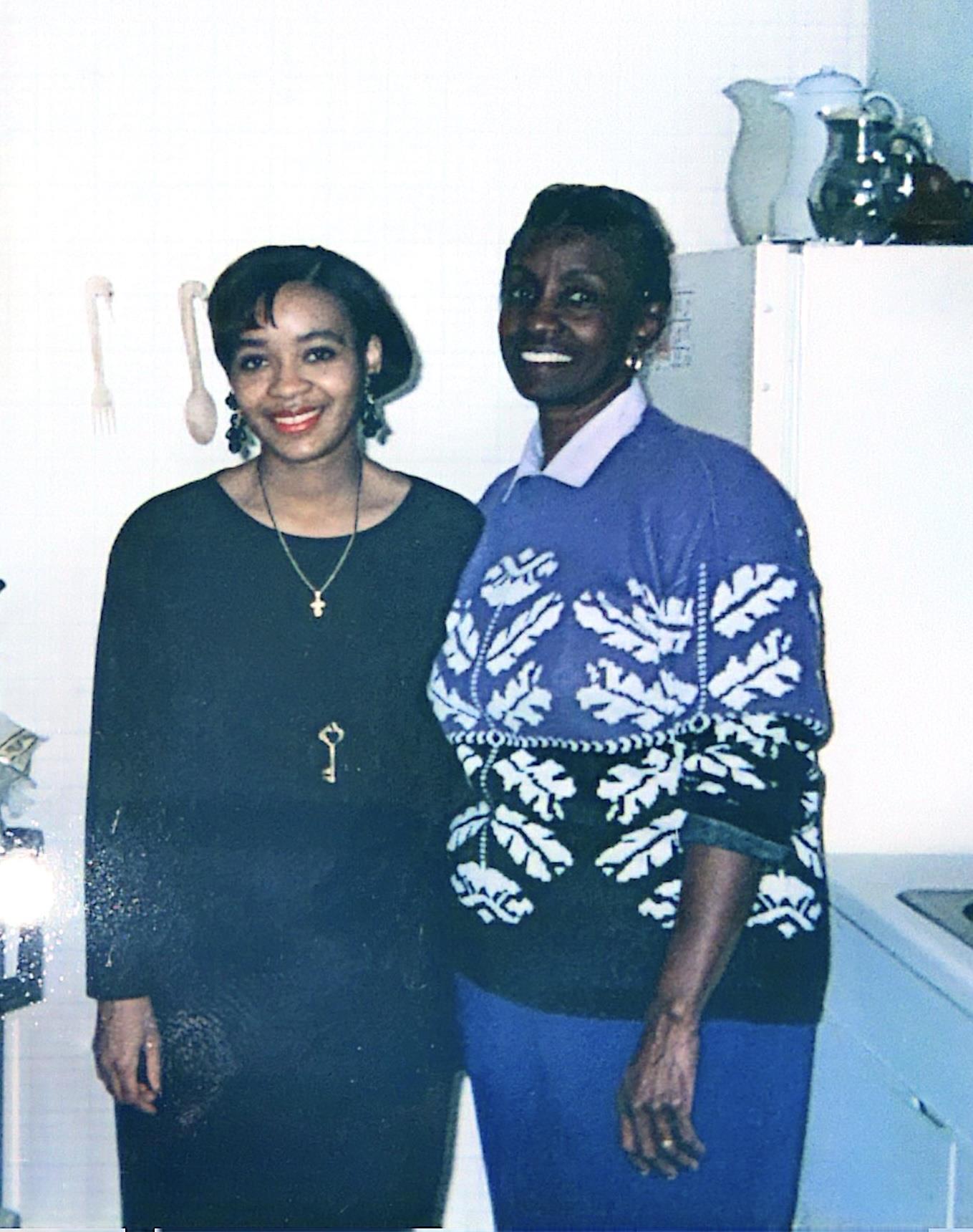 A couple of women standing in a kitchen