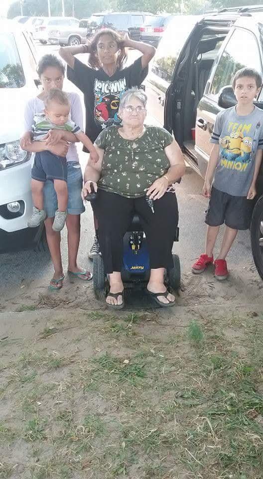 A woman in a wheelchair with two children