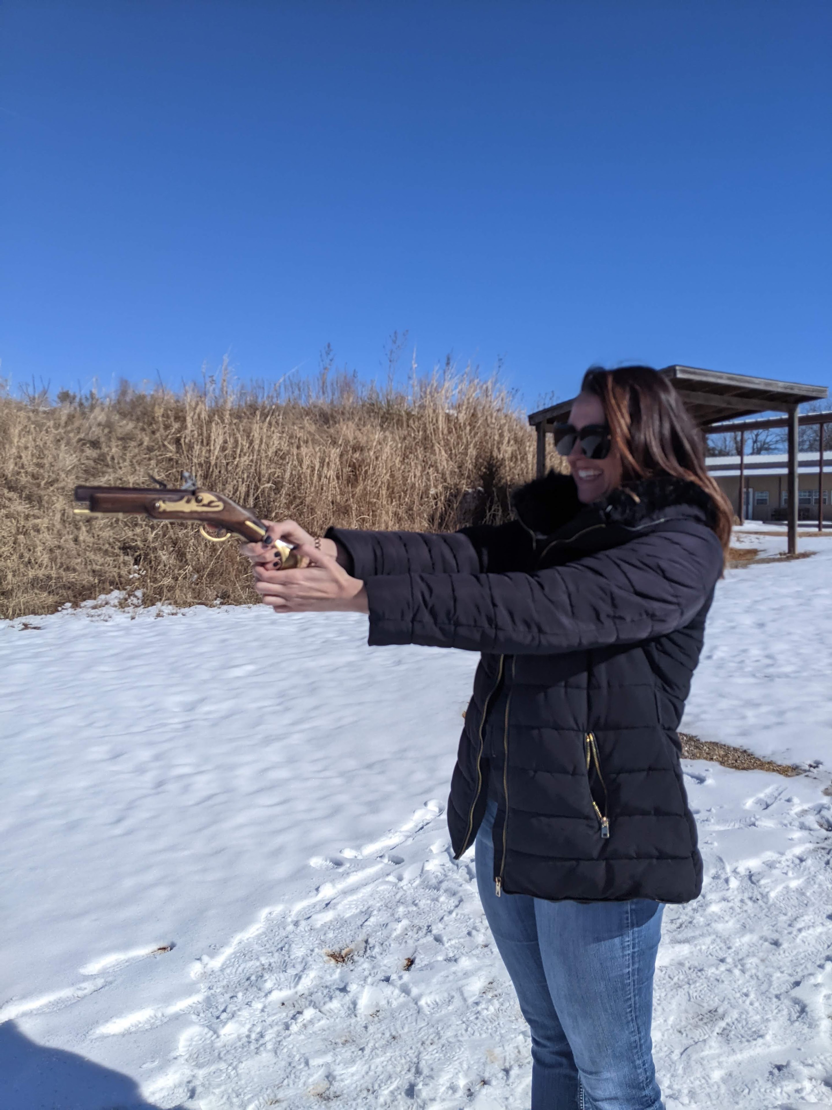 A woman holding a gun in the snow