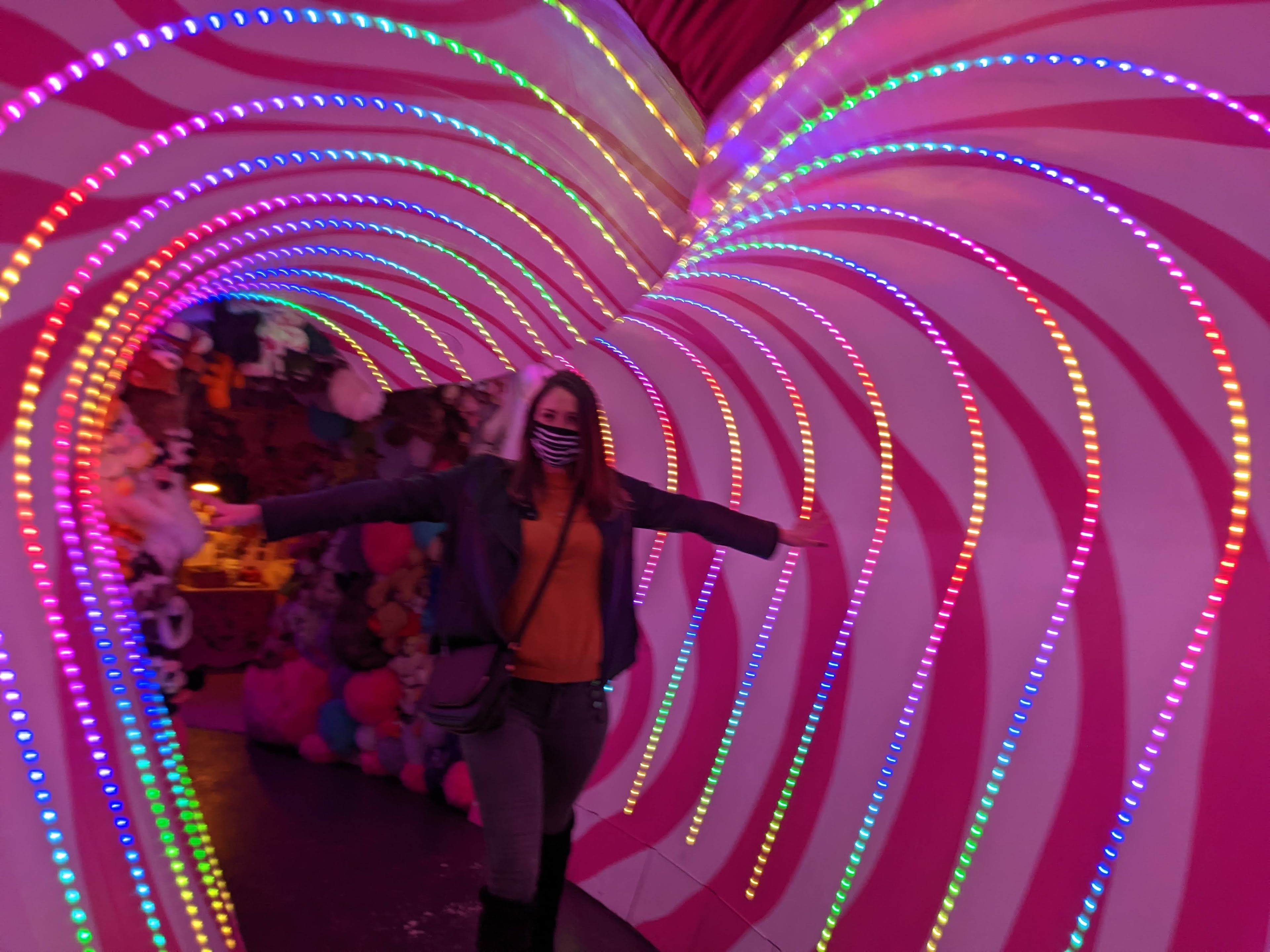 A woman standing in a tunnel with lights