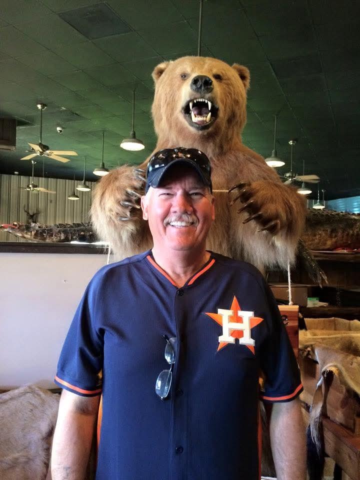 A man standing next to a stuffed bear