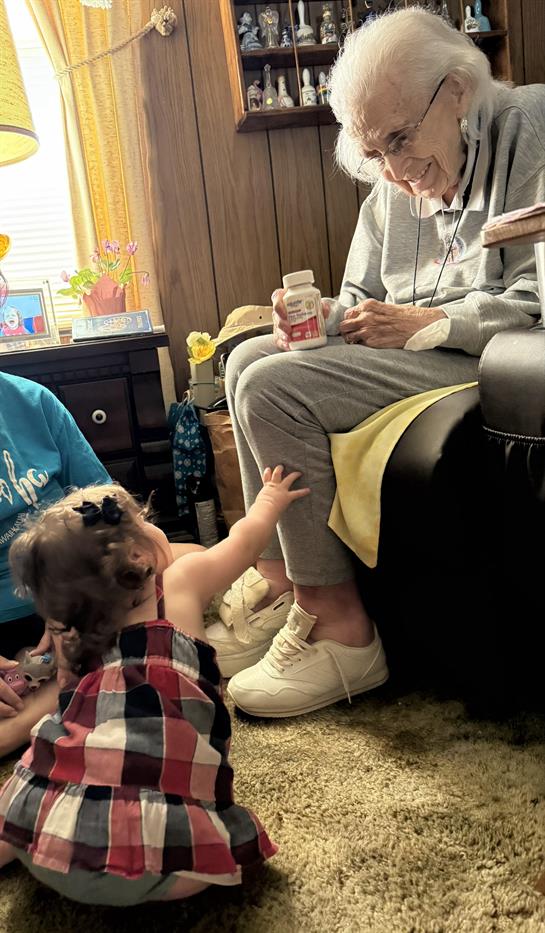 An old man sitting in a chair with a little girl