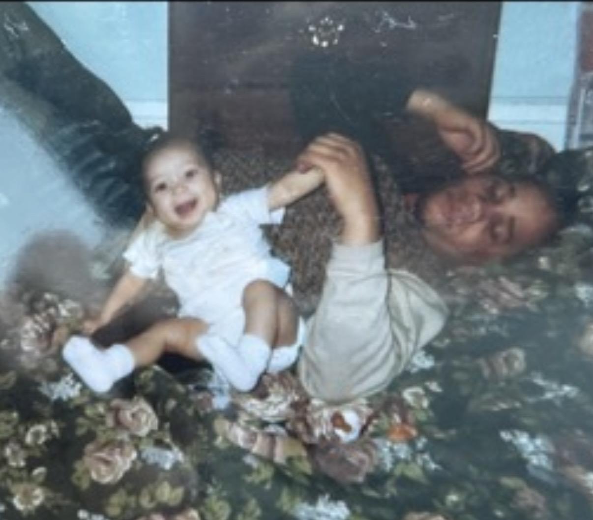A man and baby lying on a bed