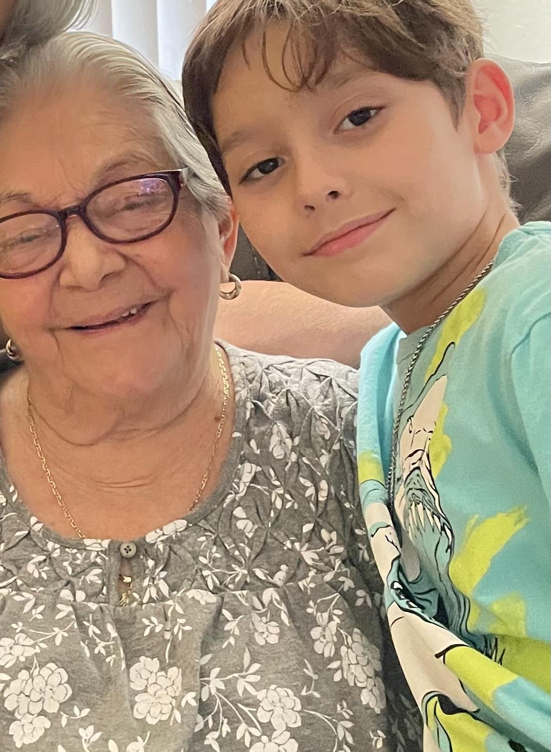 Grandmother and grandson enjoy a joyful moment together at home while smiling and embracing.