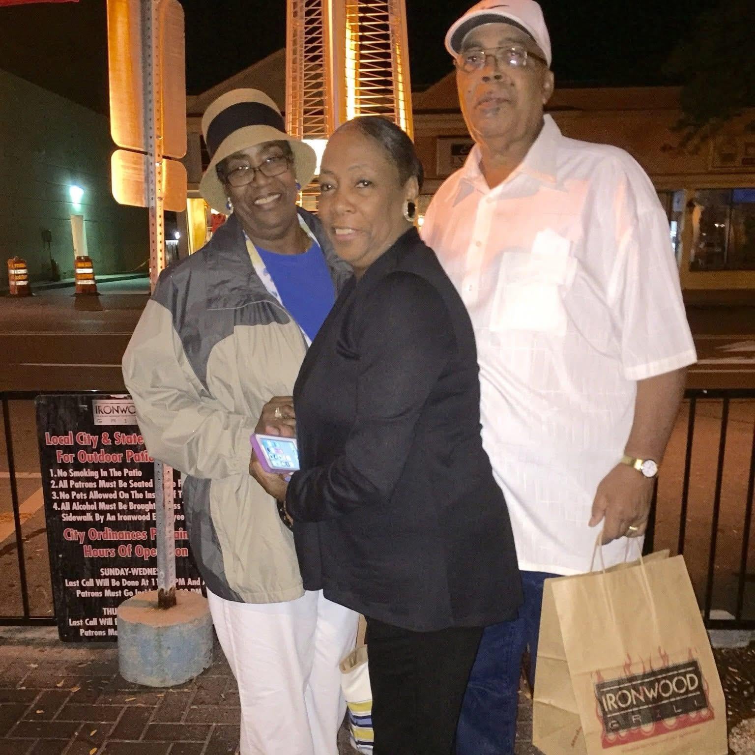 A group of people standing on a sidewalk