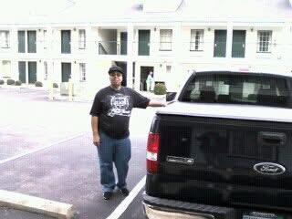 A man standing next to a black truck