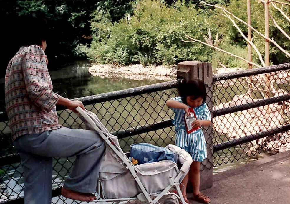 A woman and a child standing next to a fence