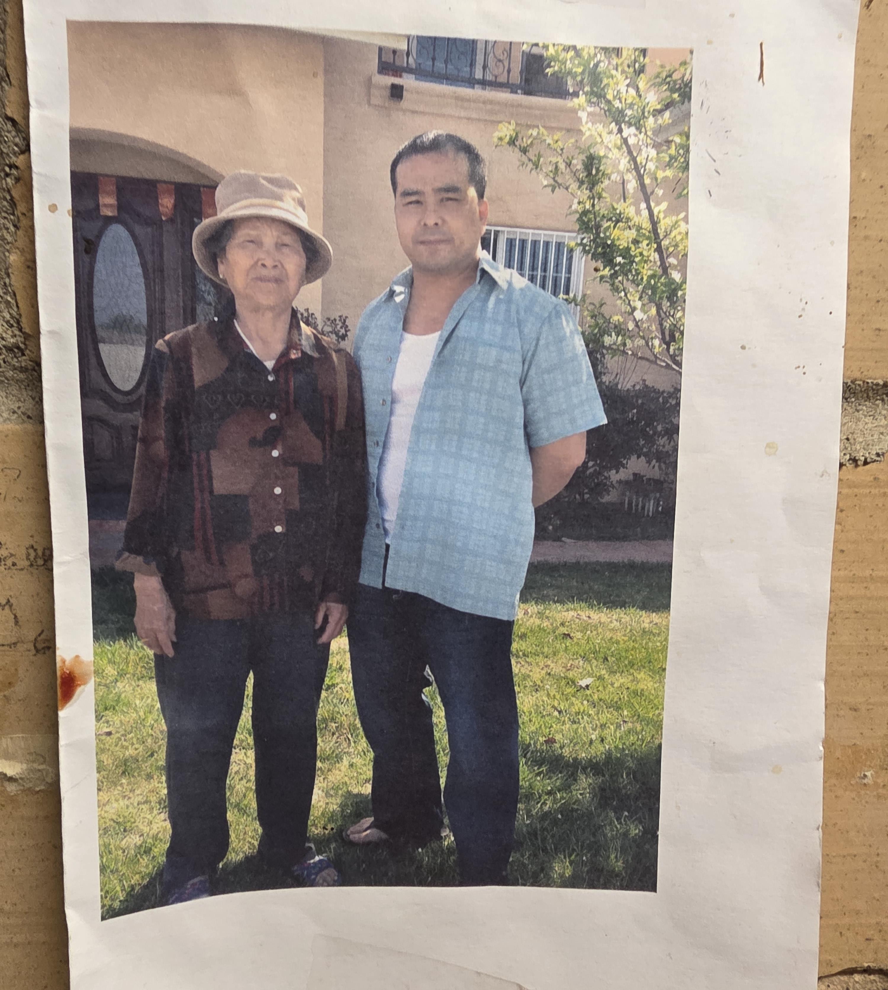 A man and woman standing in front of a house