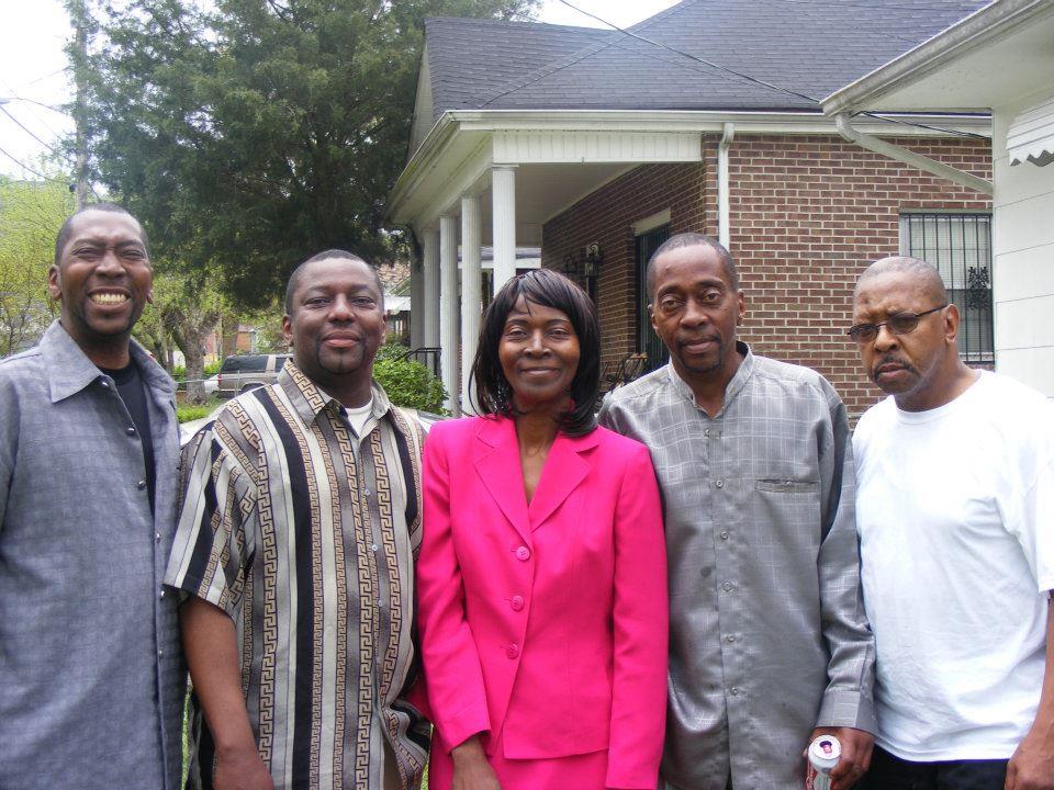 A group of people standing together outside a house