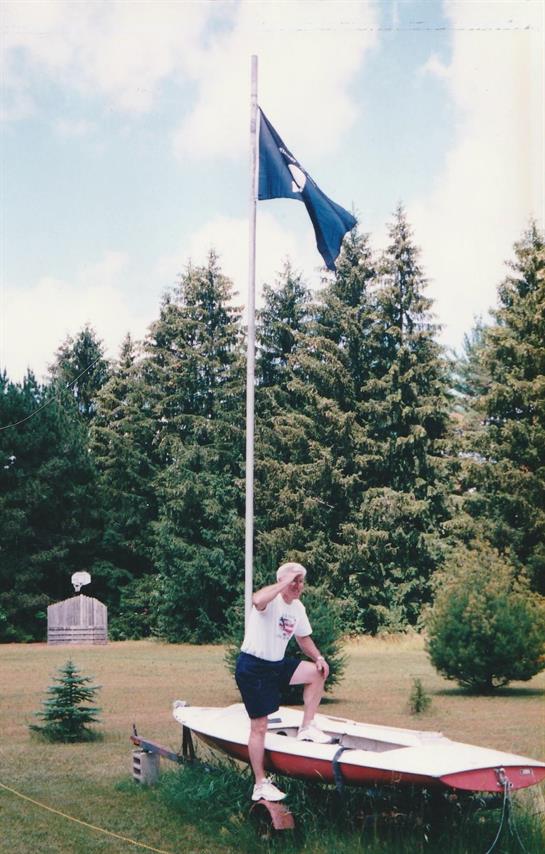 A man sitting on a flag pole