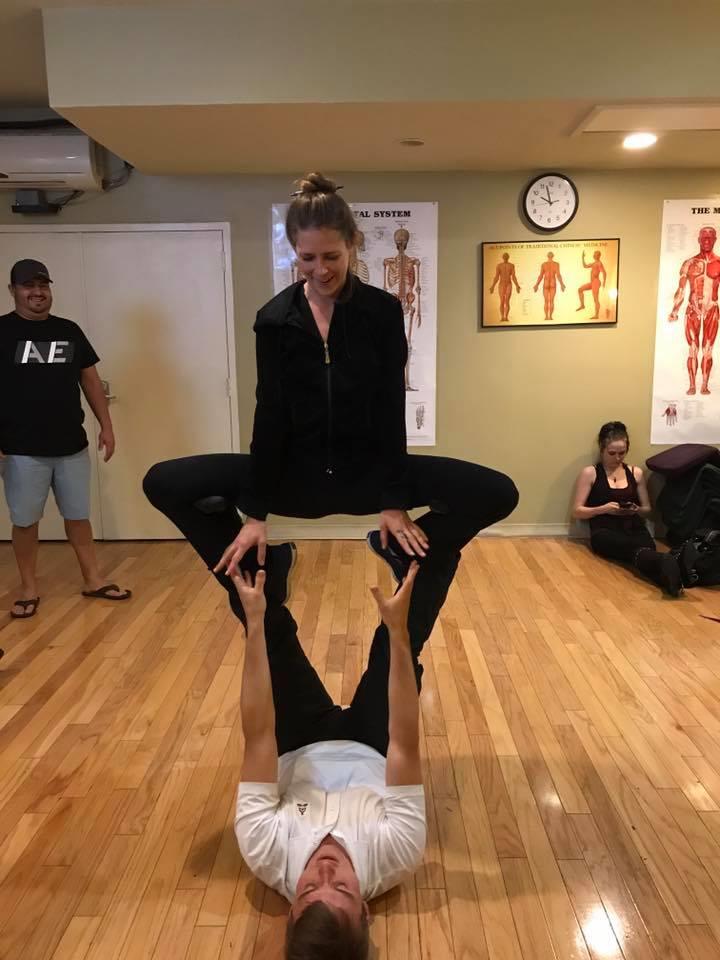 A woman standing on a man's head