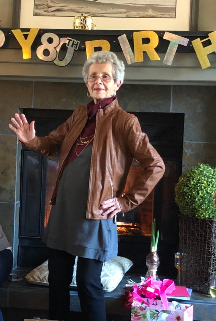 A woman standing in front of a fireplace