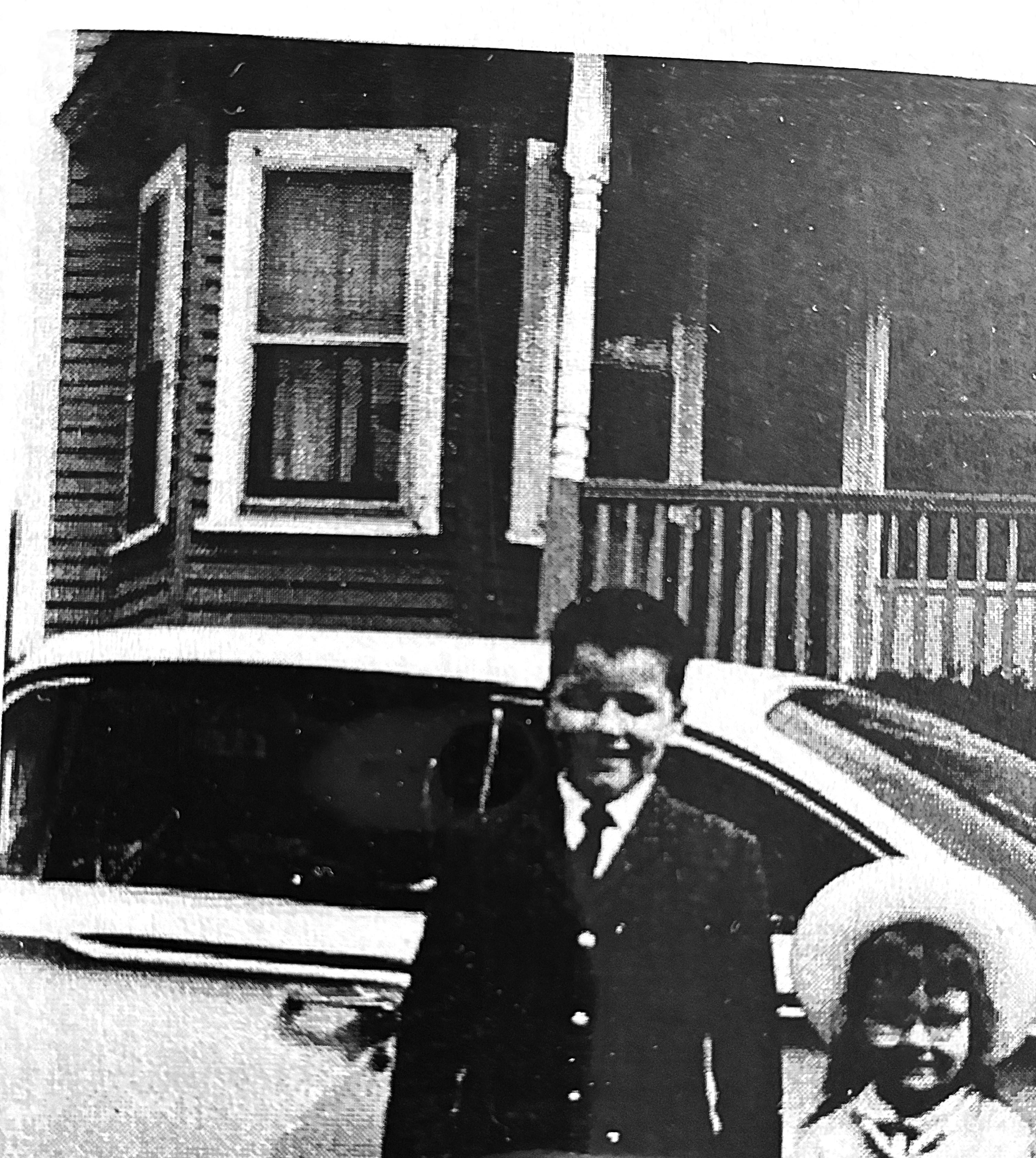 A boy and girl standing in front of a car