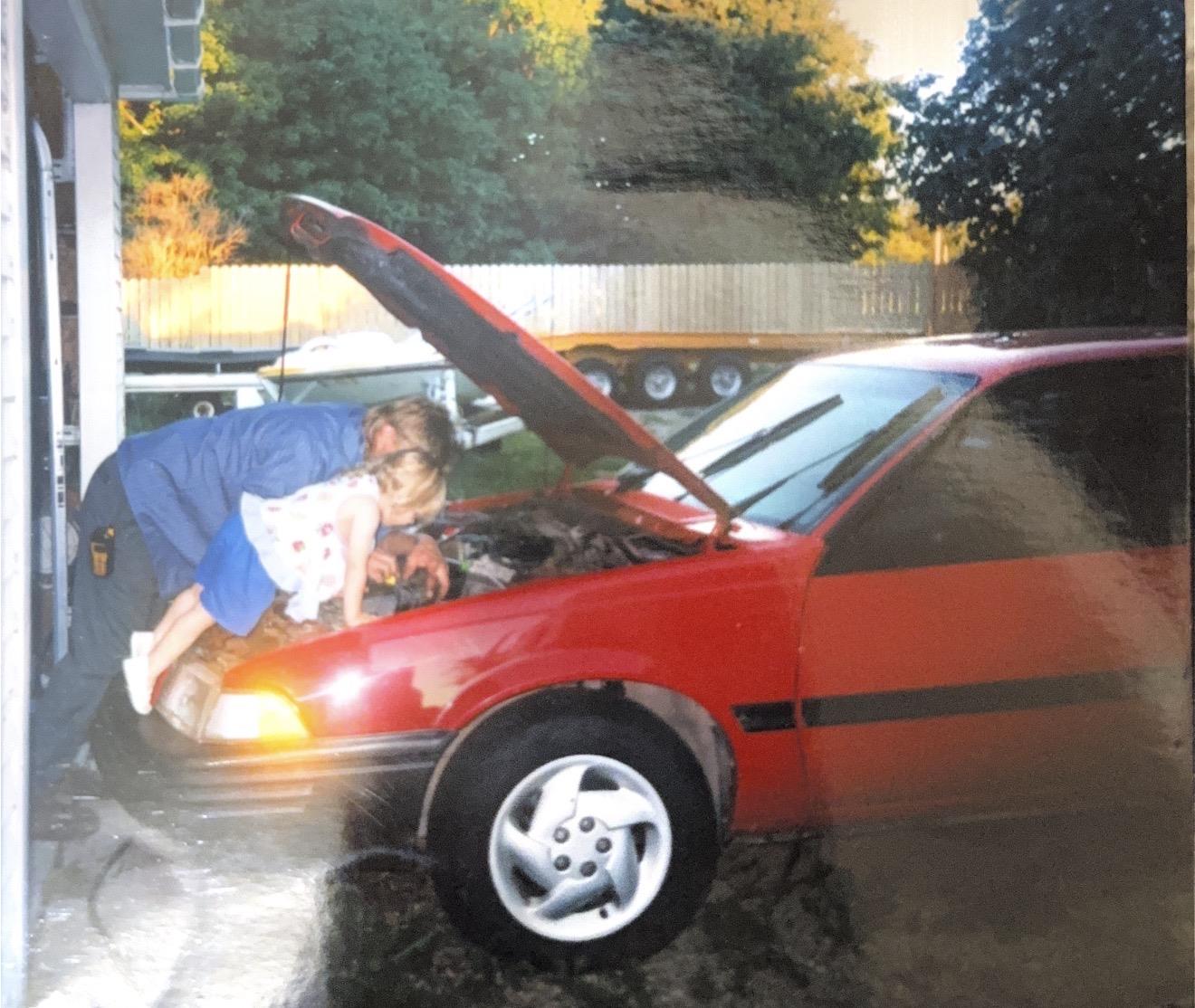 A woman and child in a car with the hood up