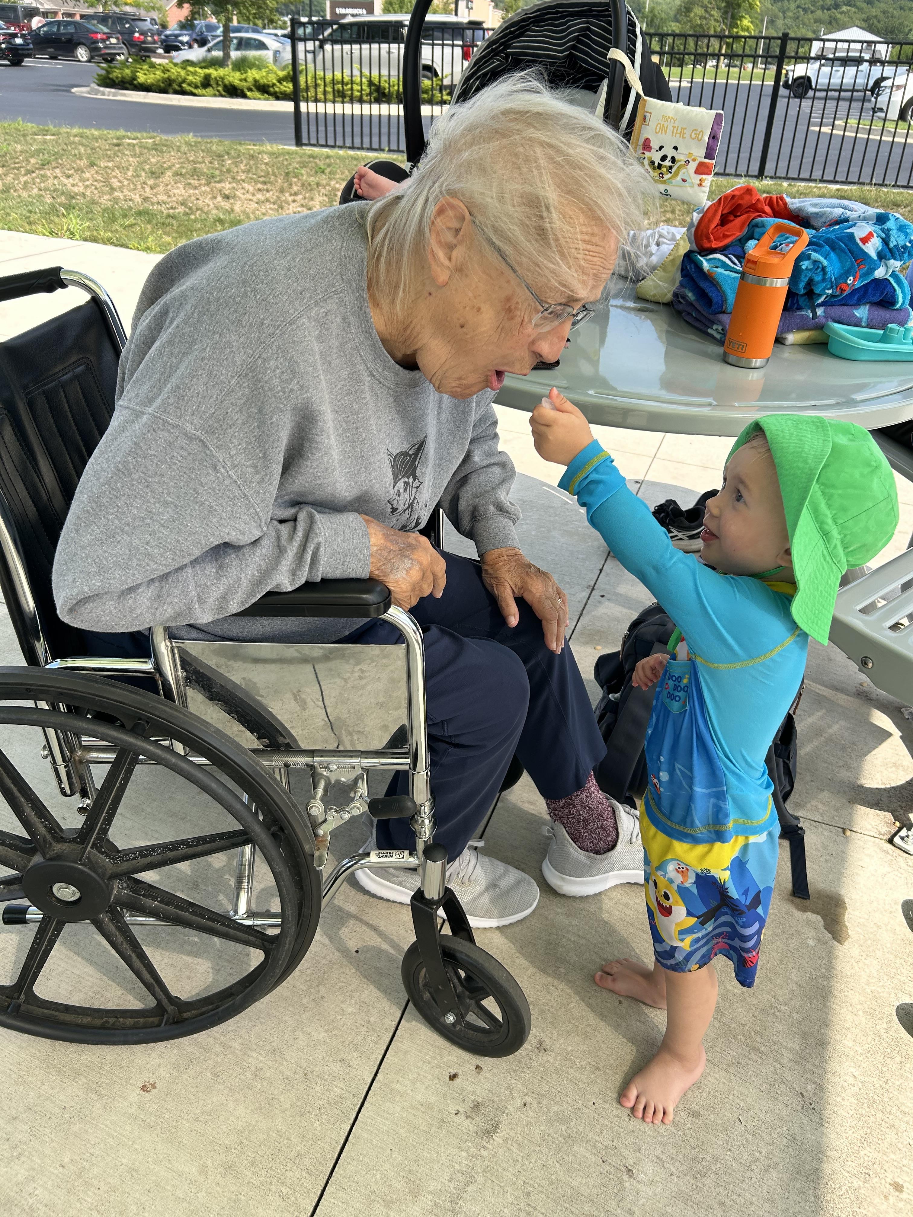 An old woman in a wheelchair with a child