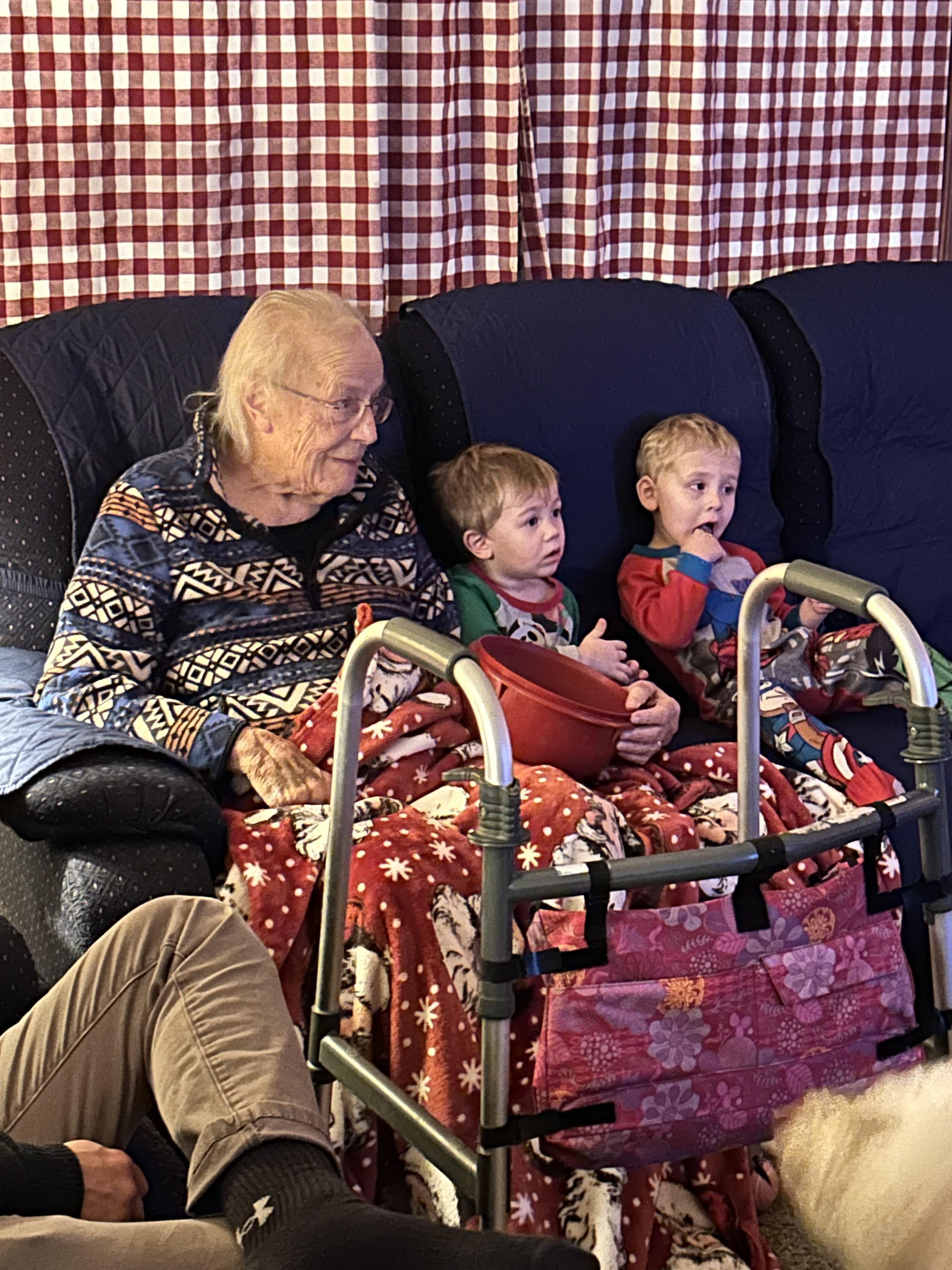 A woman and two boys sitting on a couch