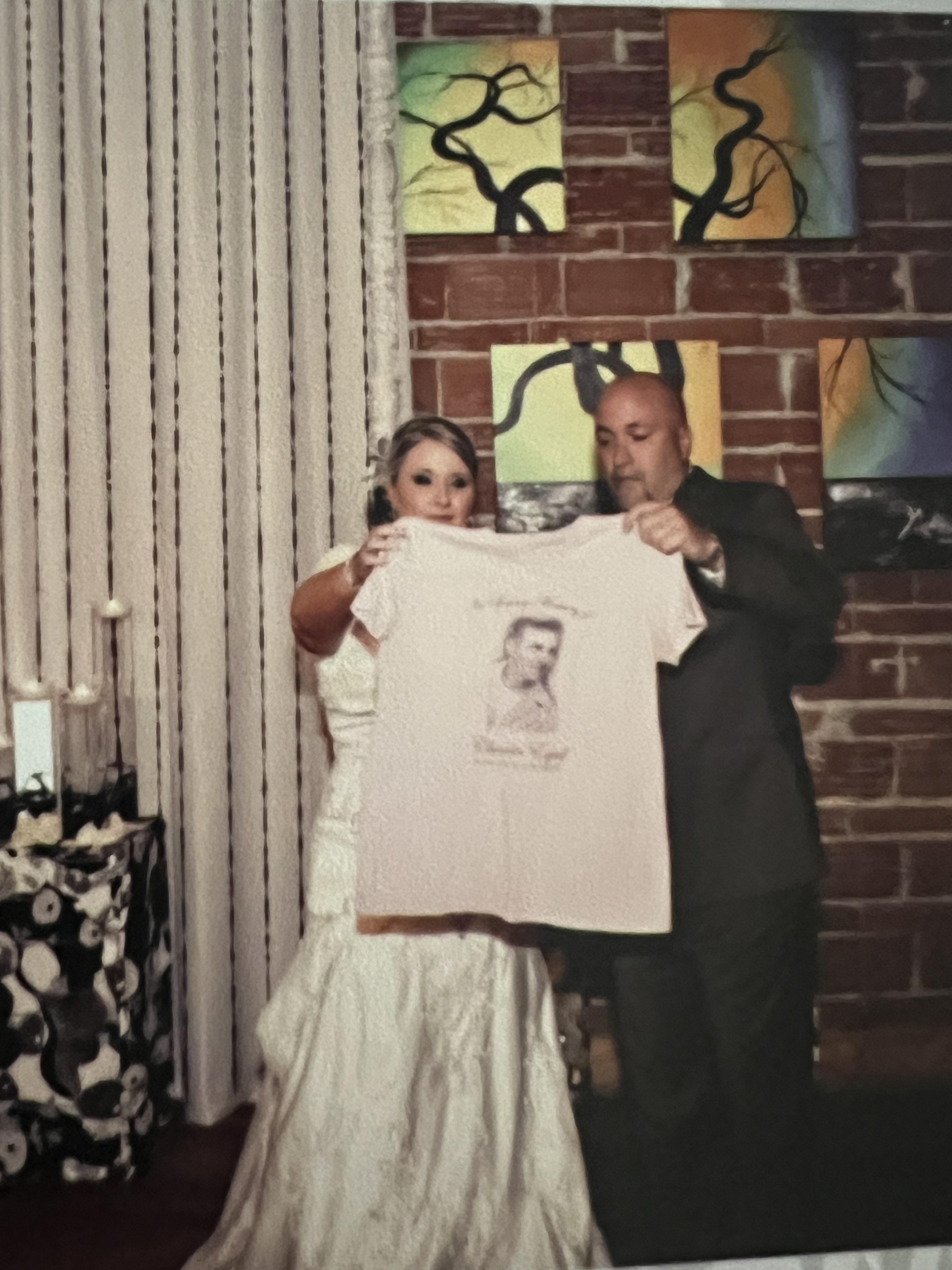 A man and woman holding a shirt