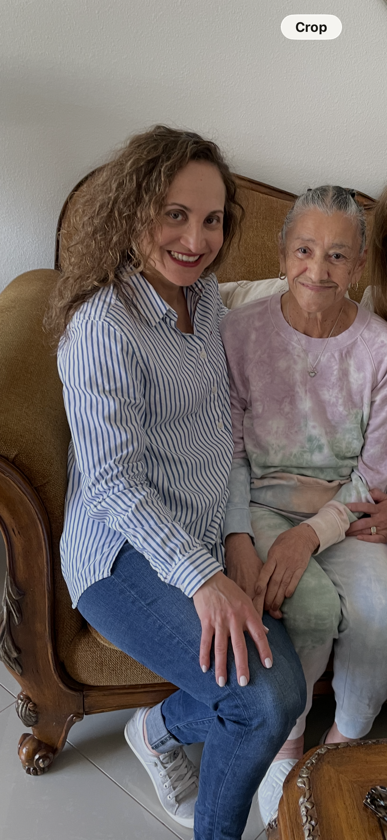 A woman sitting on a couch with an older woman