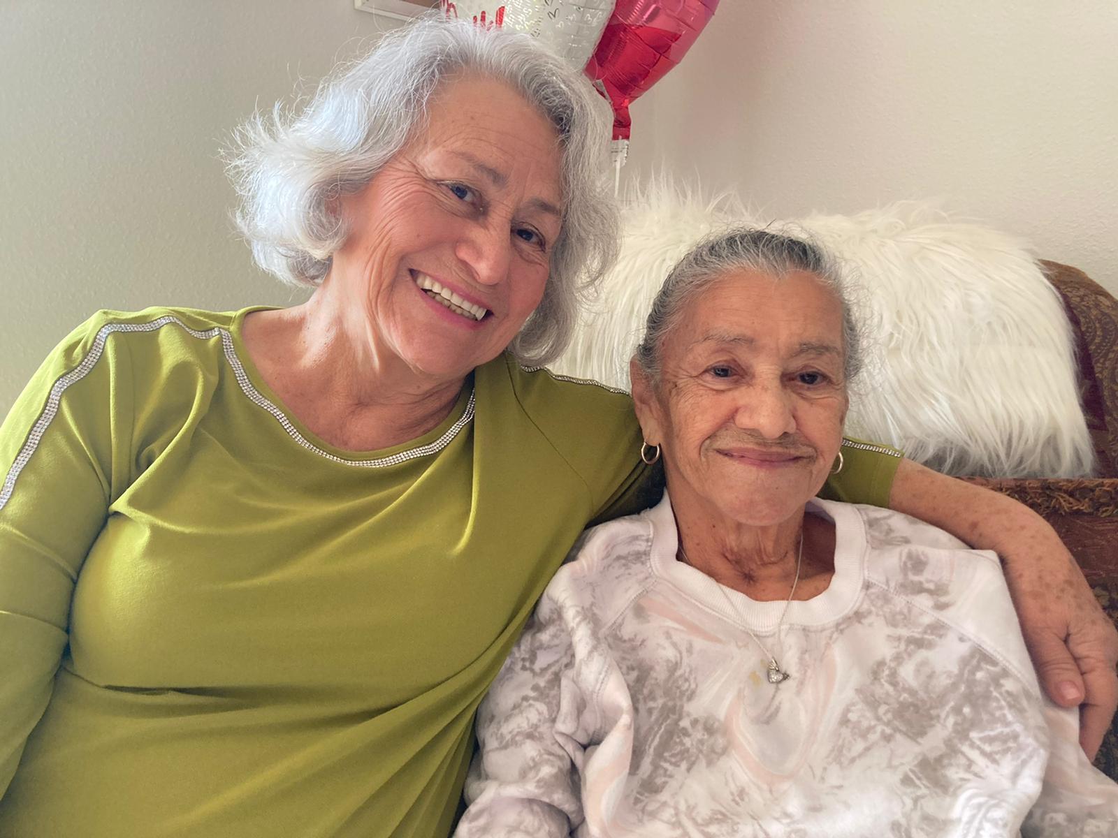 Two women sitting on a bed