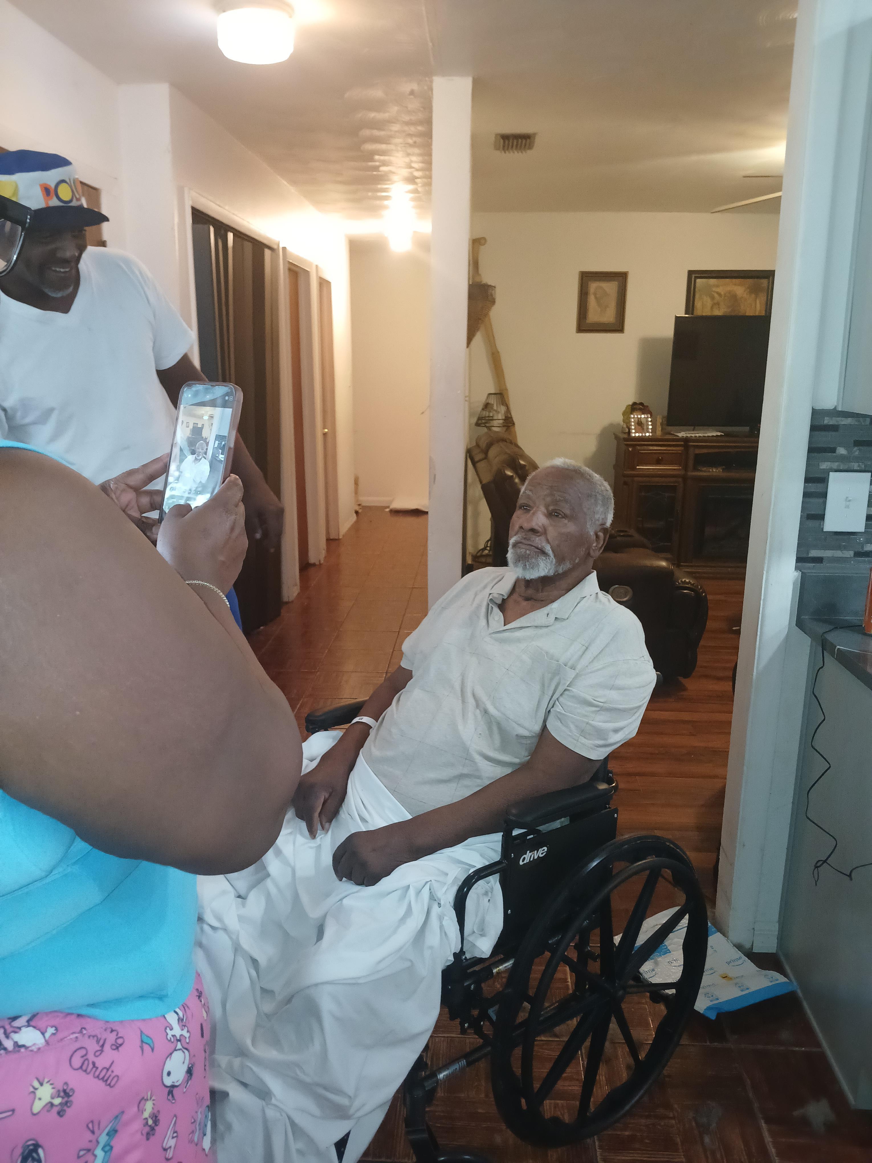 A man in a wheelchair taking a picture of a man in a wheelchair