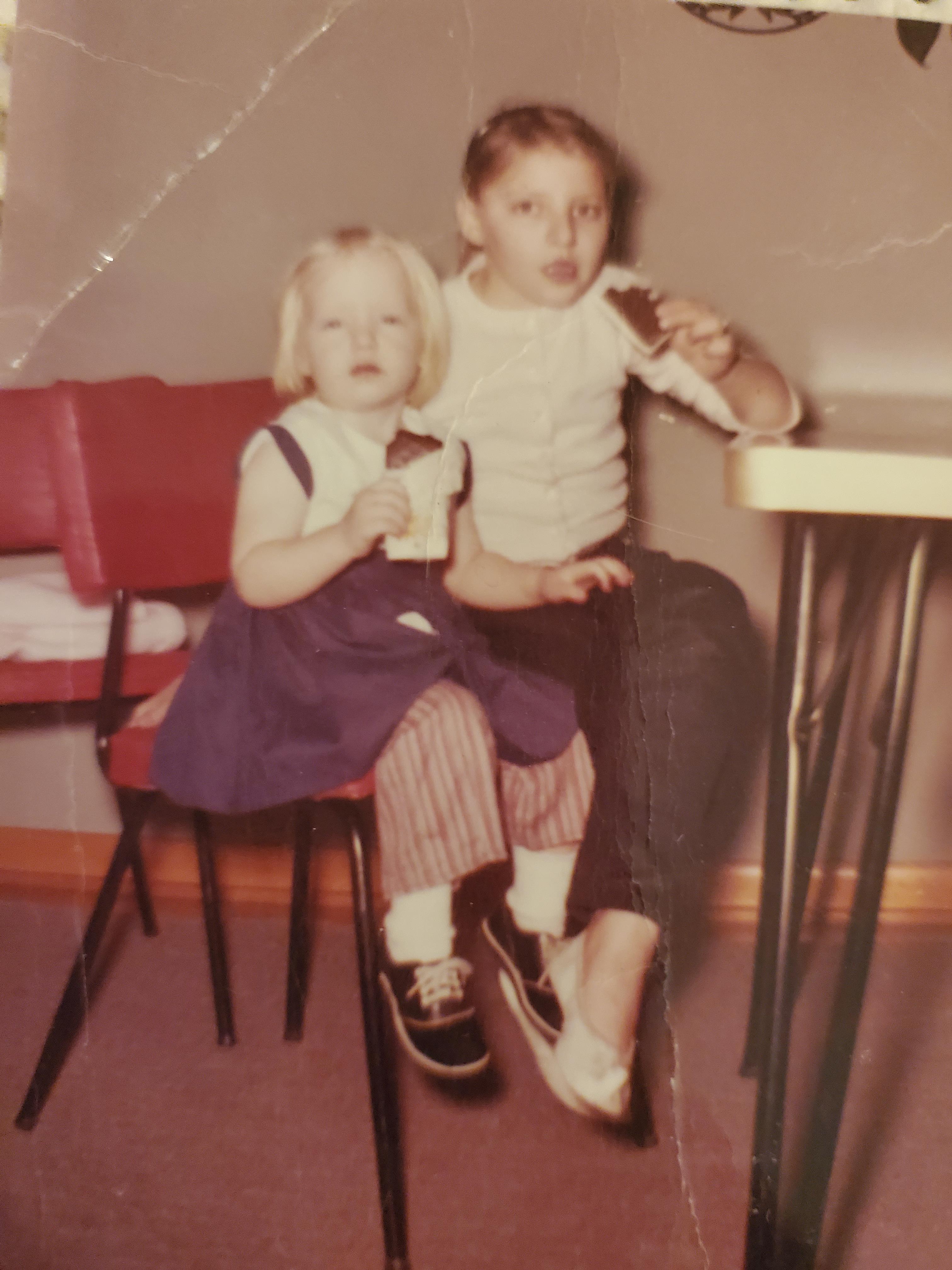 A boy and girl sitting on a chair