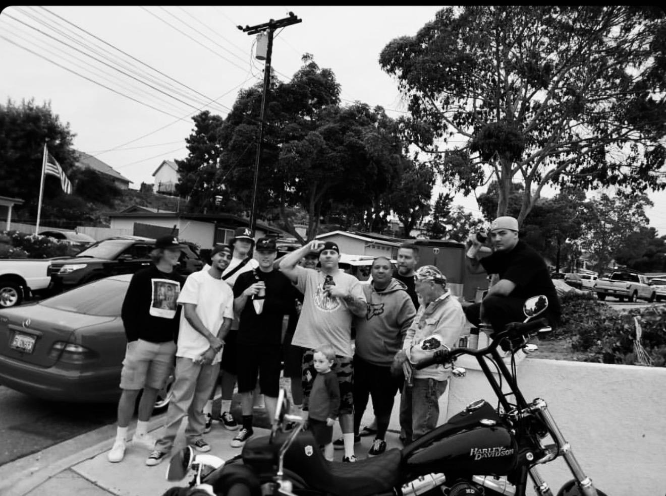 A group of men standing next to a motorcycle