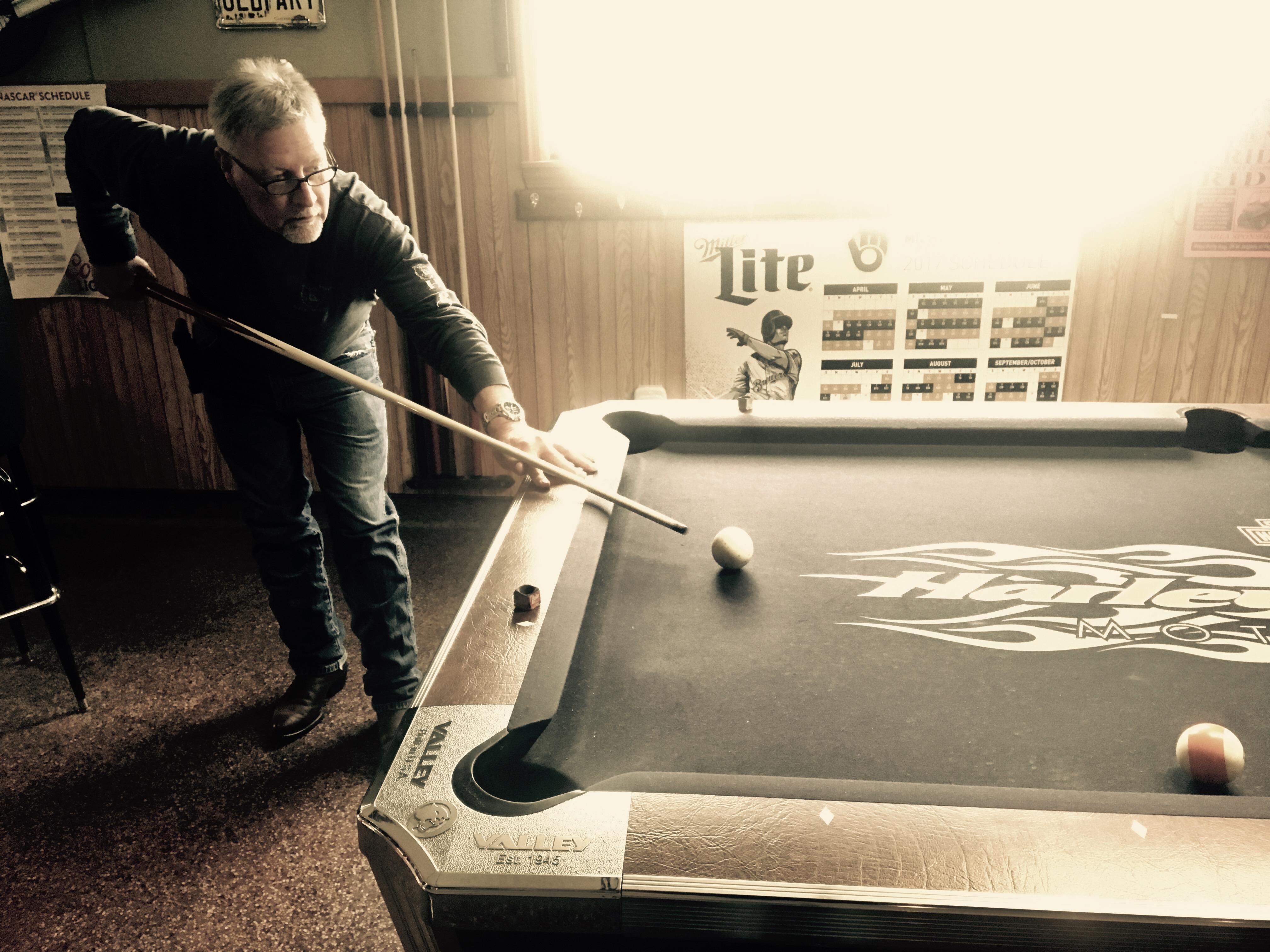 A man playing pool with a stick