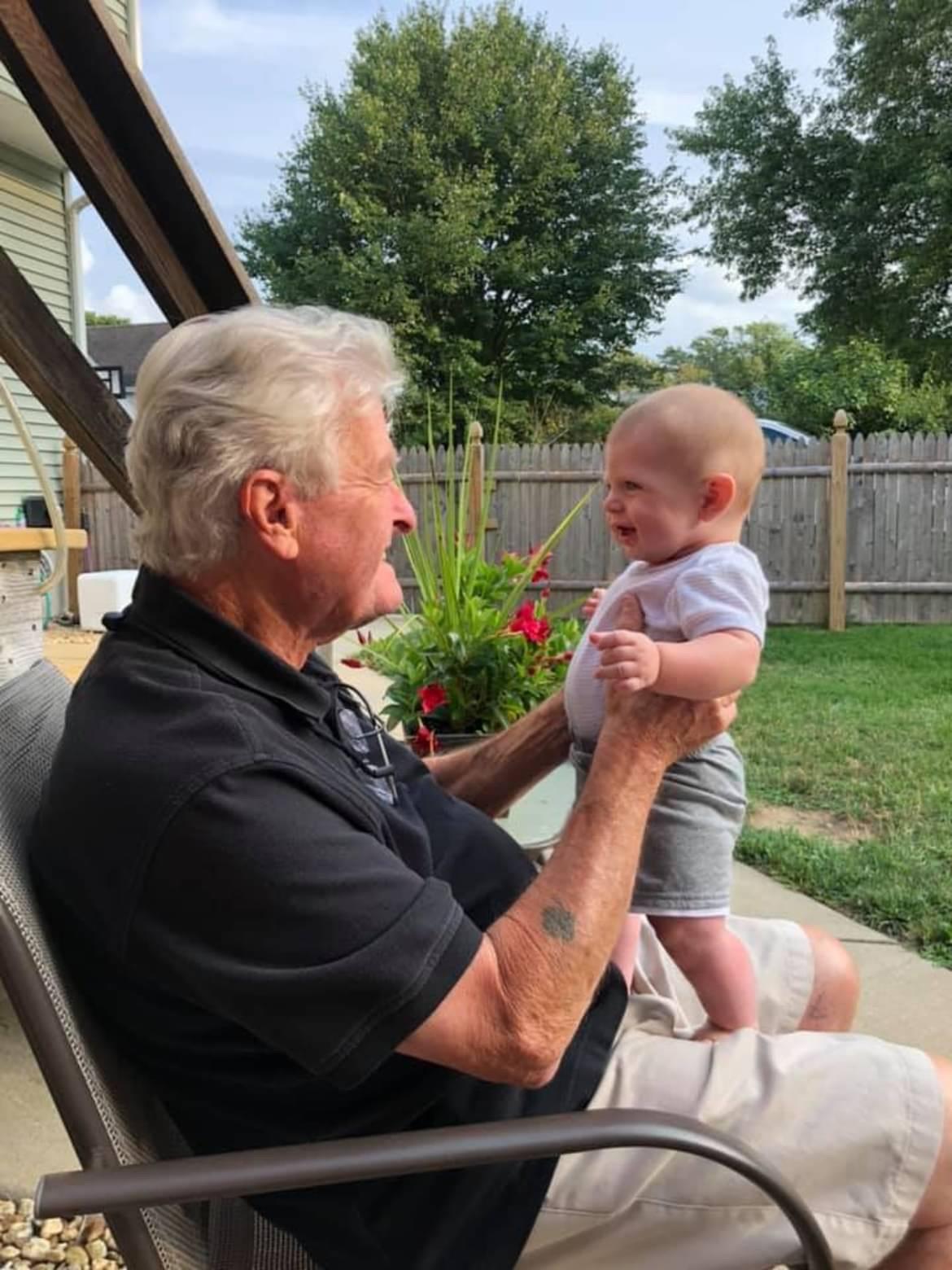 An old man holding a baby