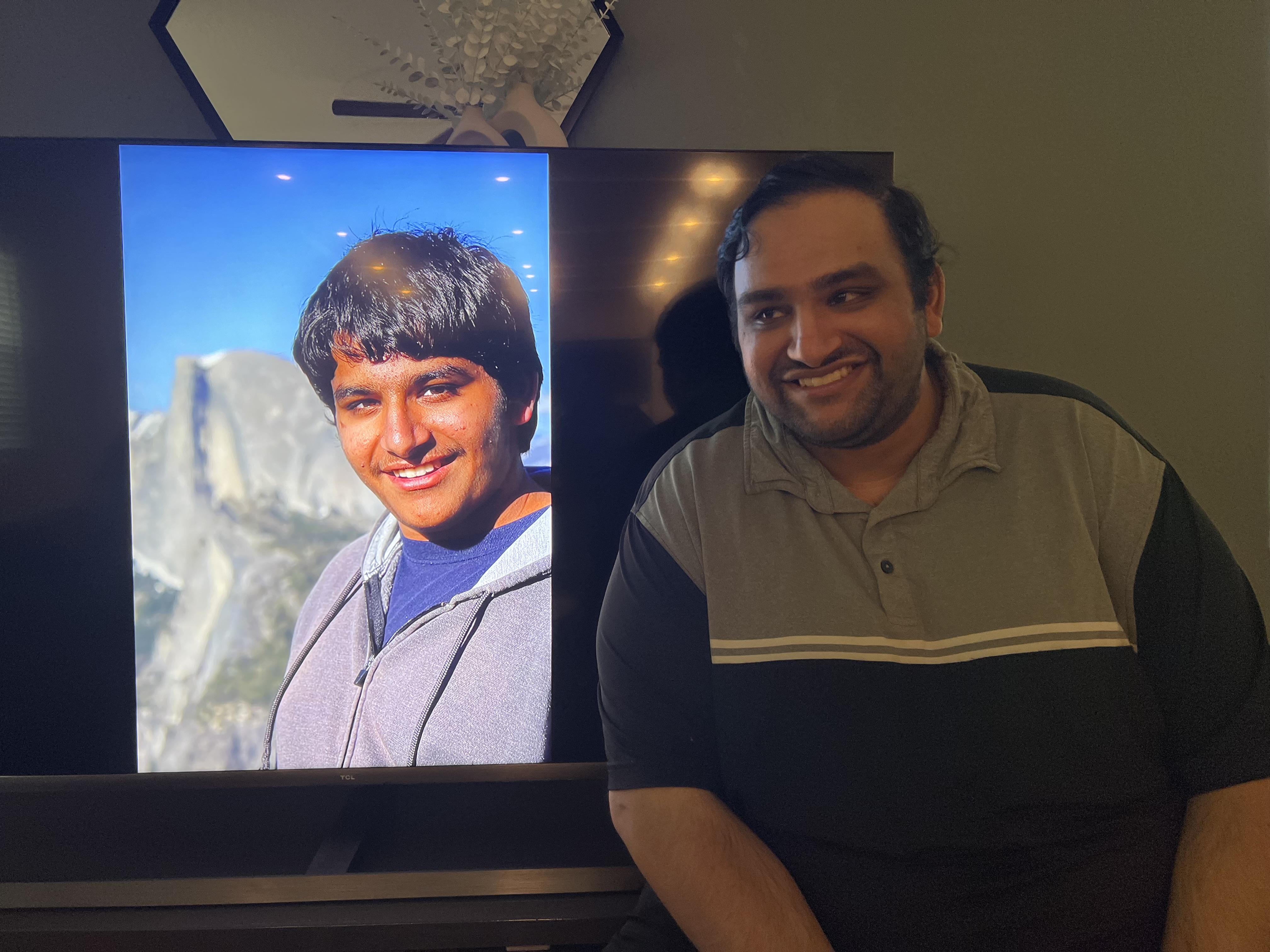 A man sitting next to a television