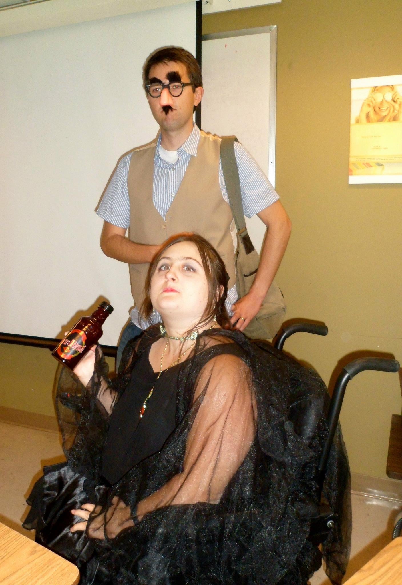 A man standing behind a woman in a wheelchair