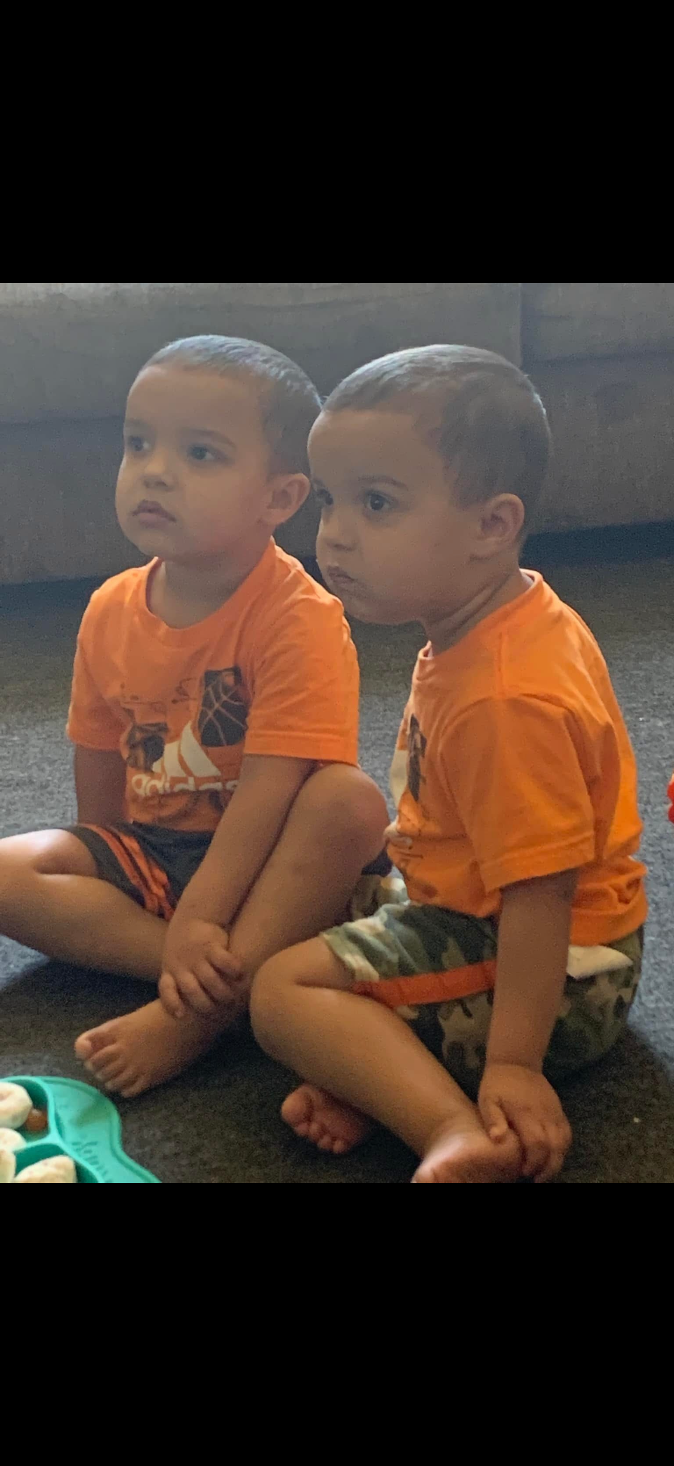 Two young boys sitting on the floor