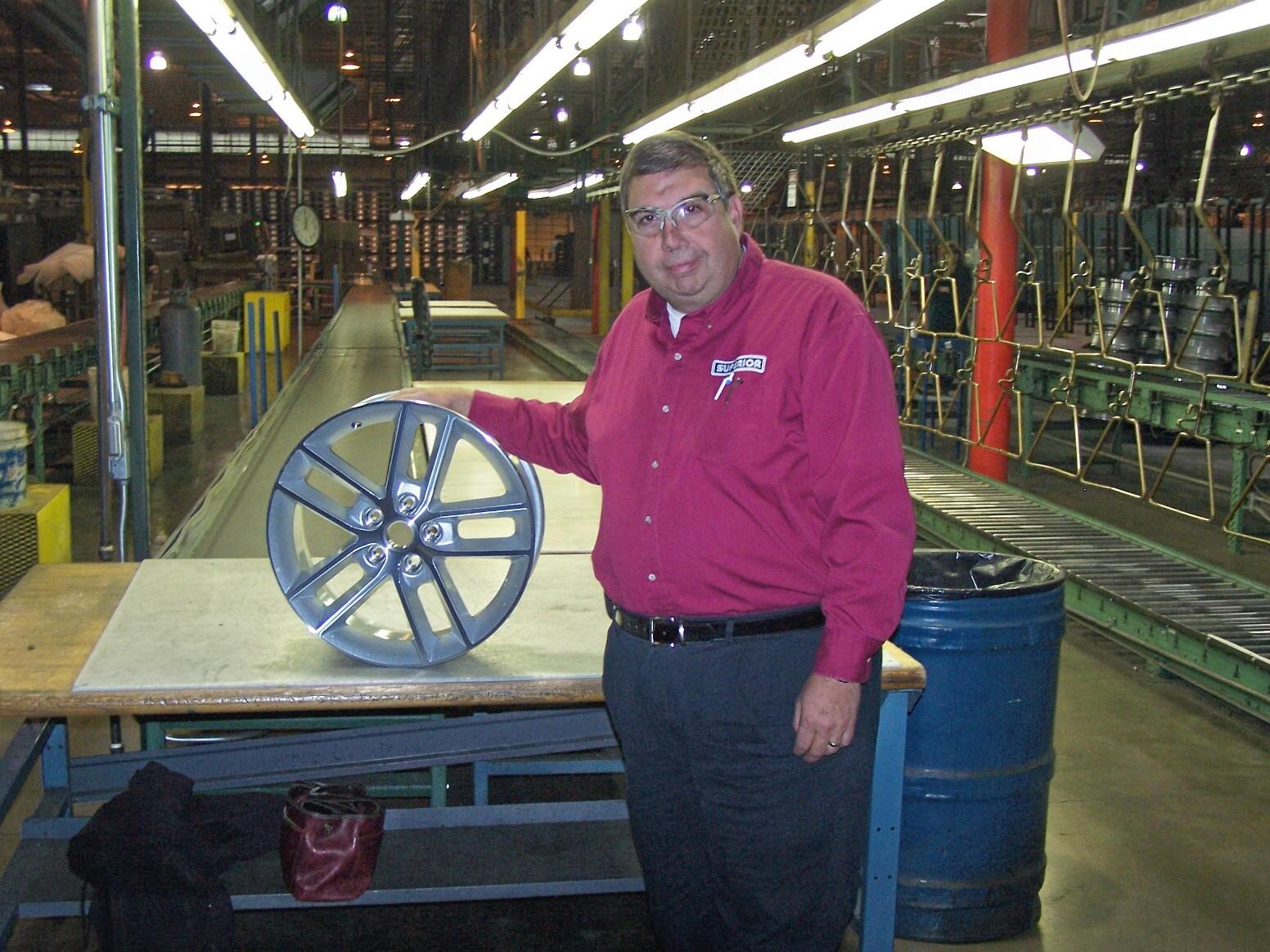 A man standing next to a wheel