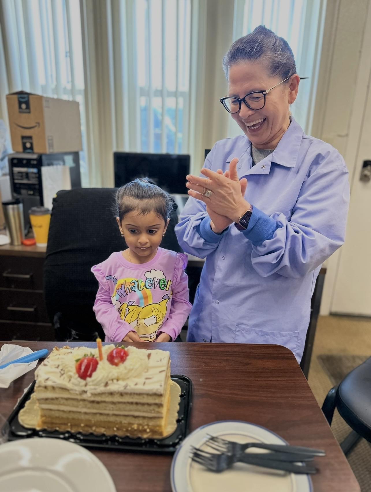 A woman and a girl in front of a cake