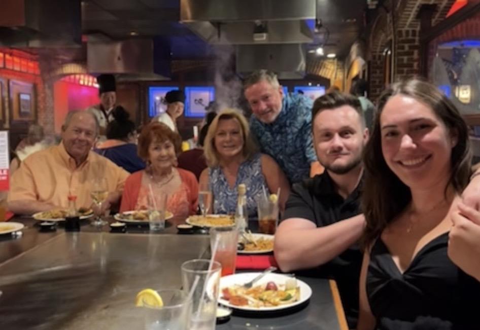 A group of people sitting at a table with food
