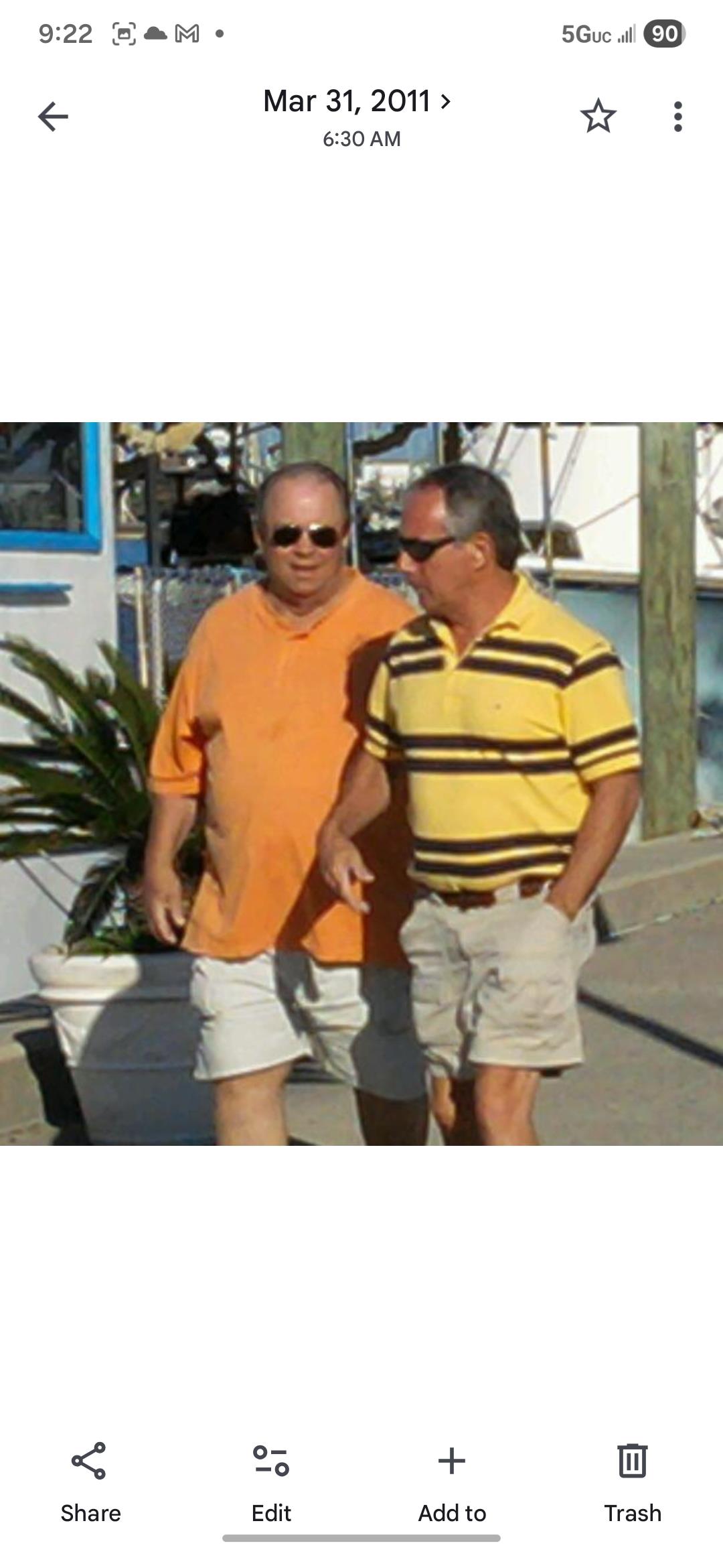 A pair of men walking on a sidewalk