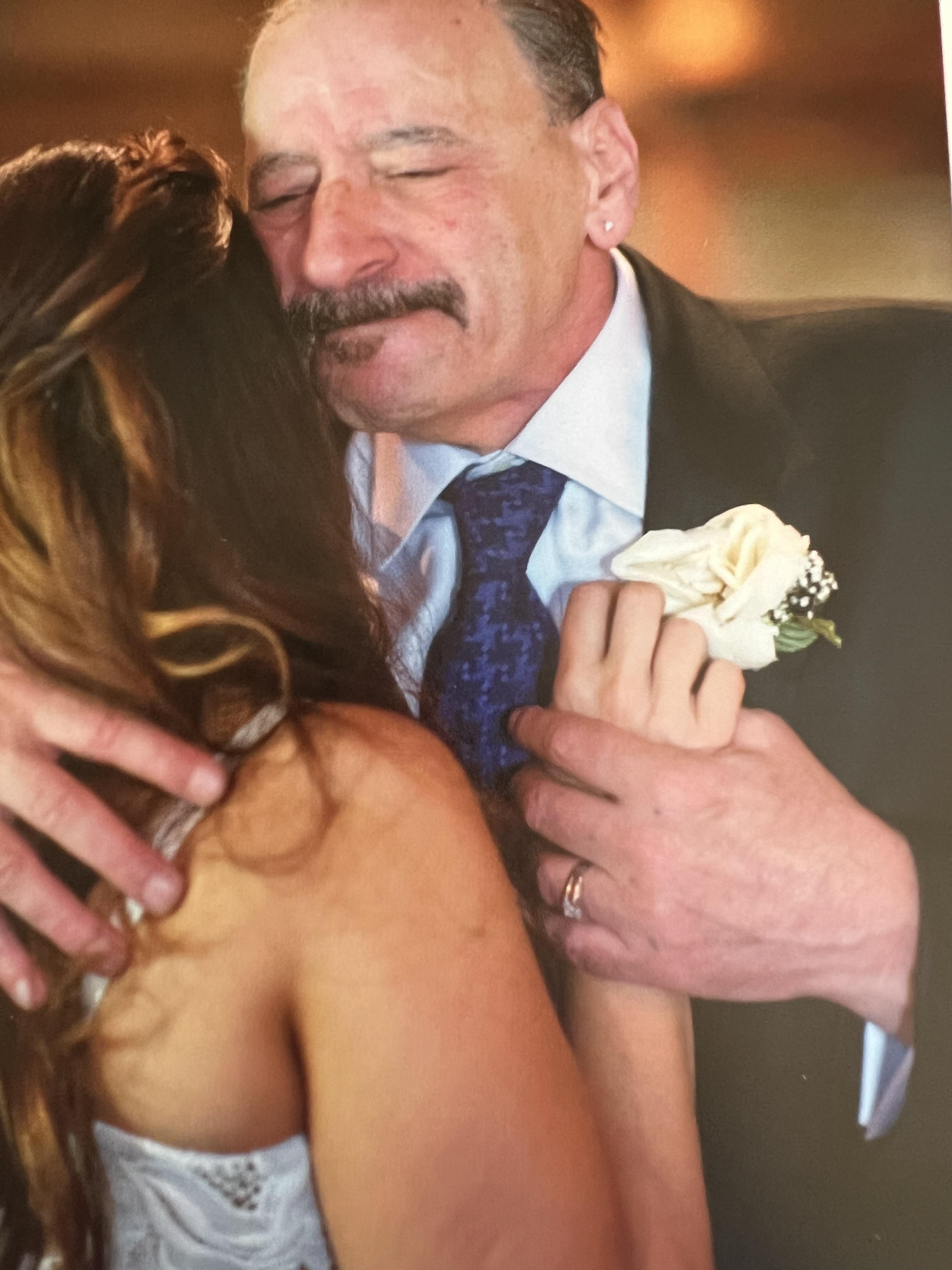 A man in a suit hugging a woman