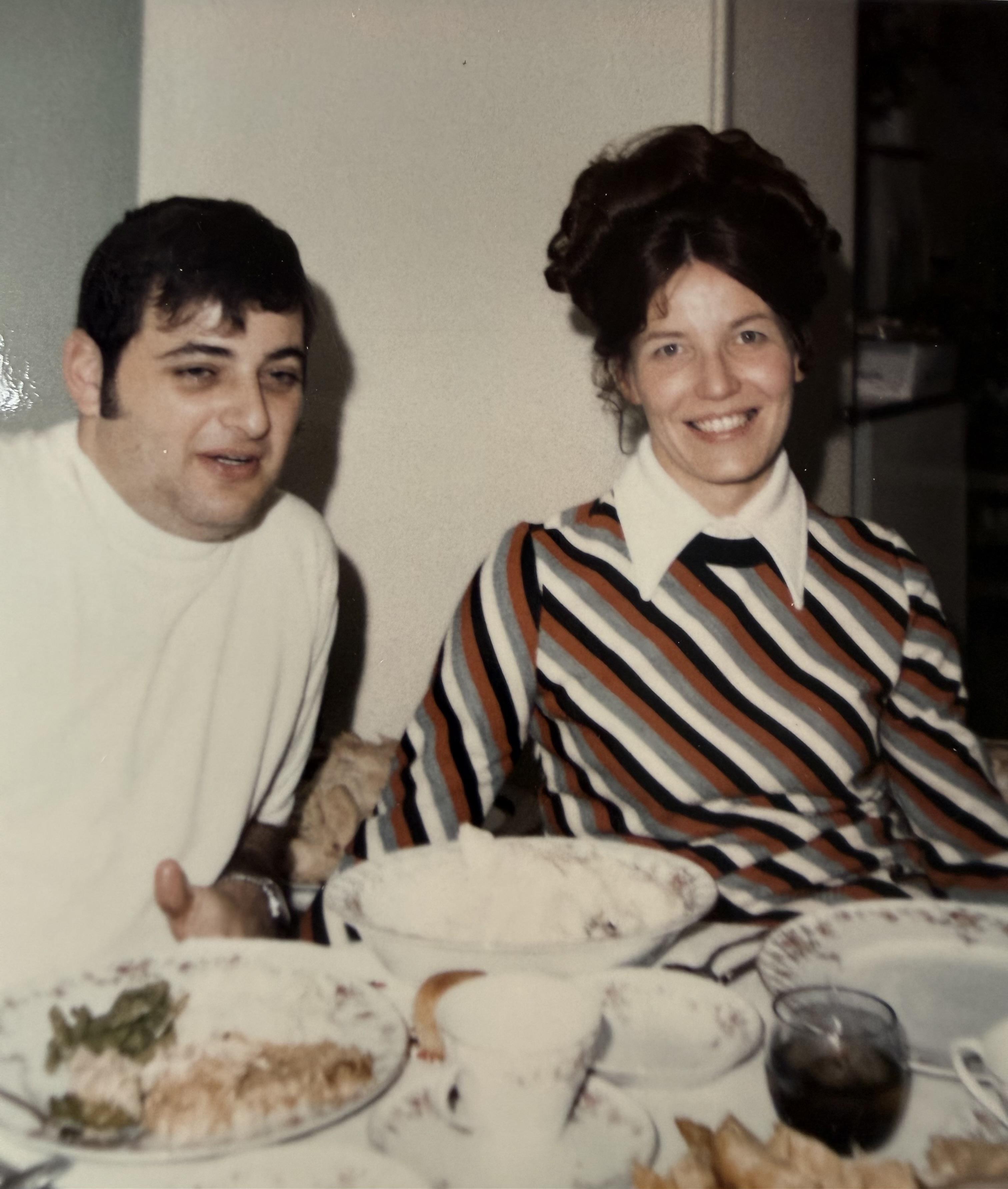 A man and woman sitting at a table with plates