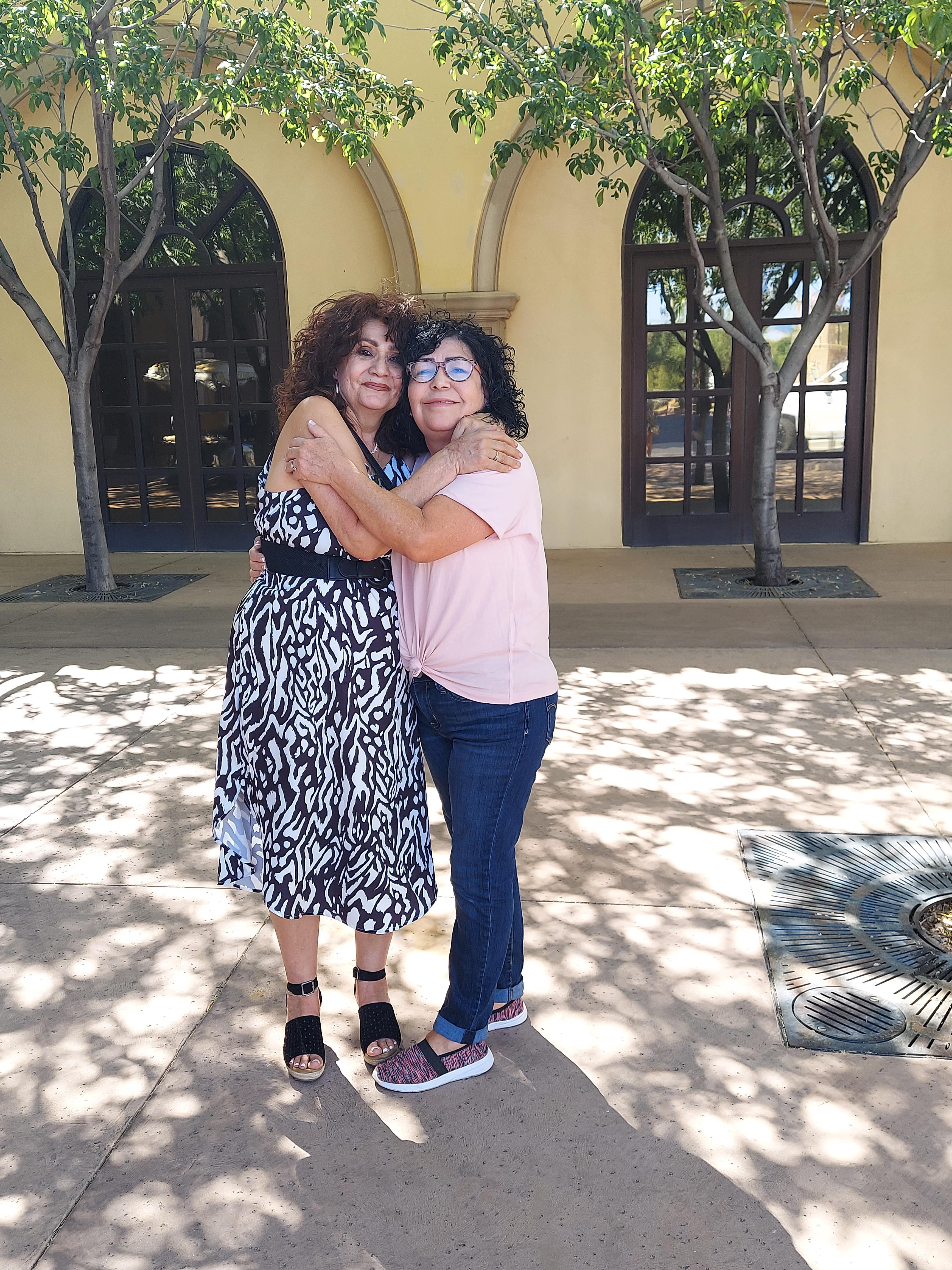 Two women hugging each other
