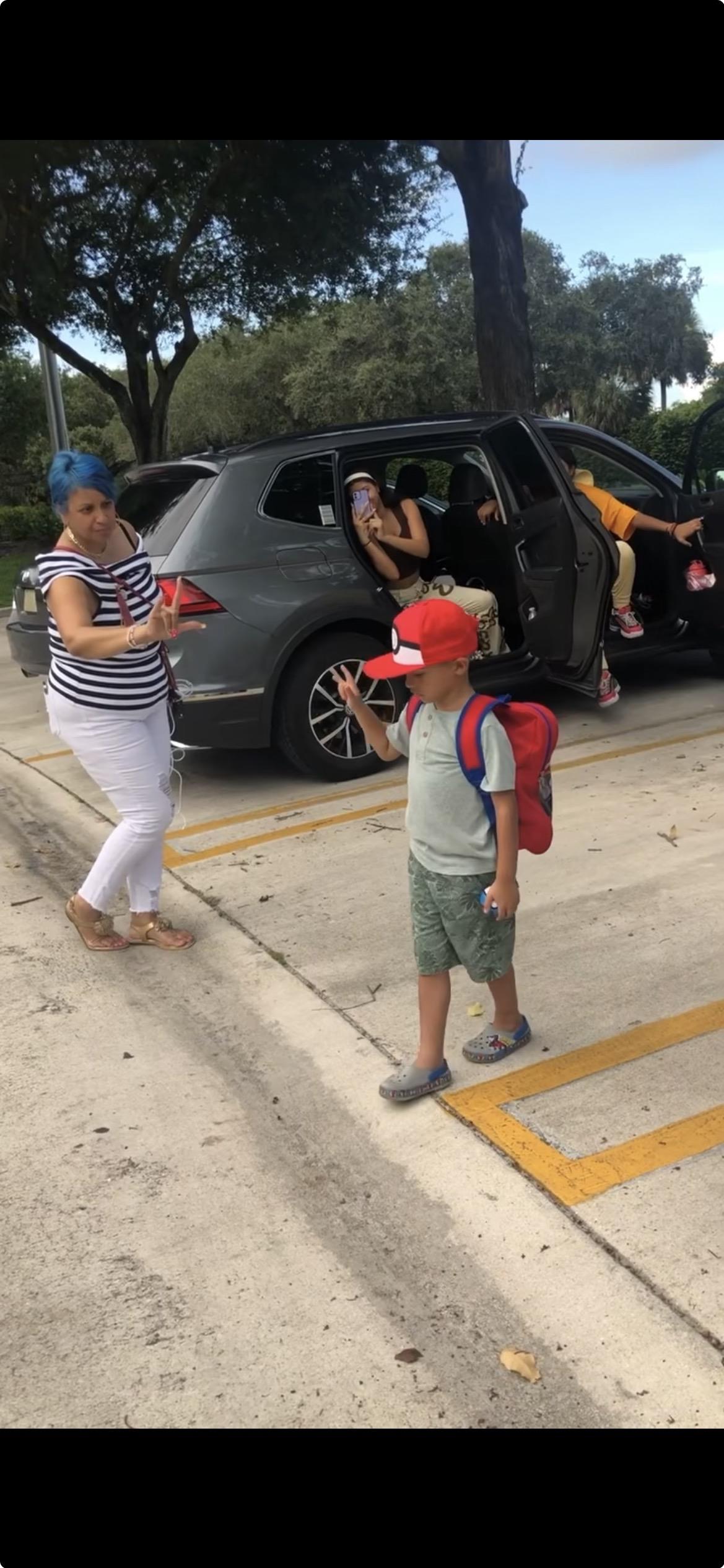A woman and a boy standing in a parking lot