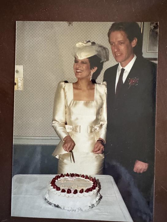 A man and woman standing next to a cake