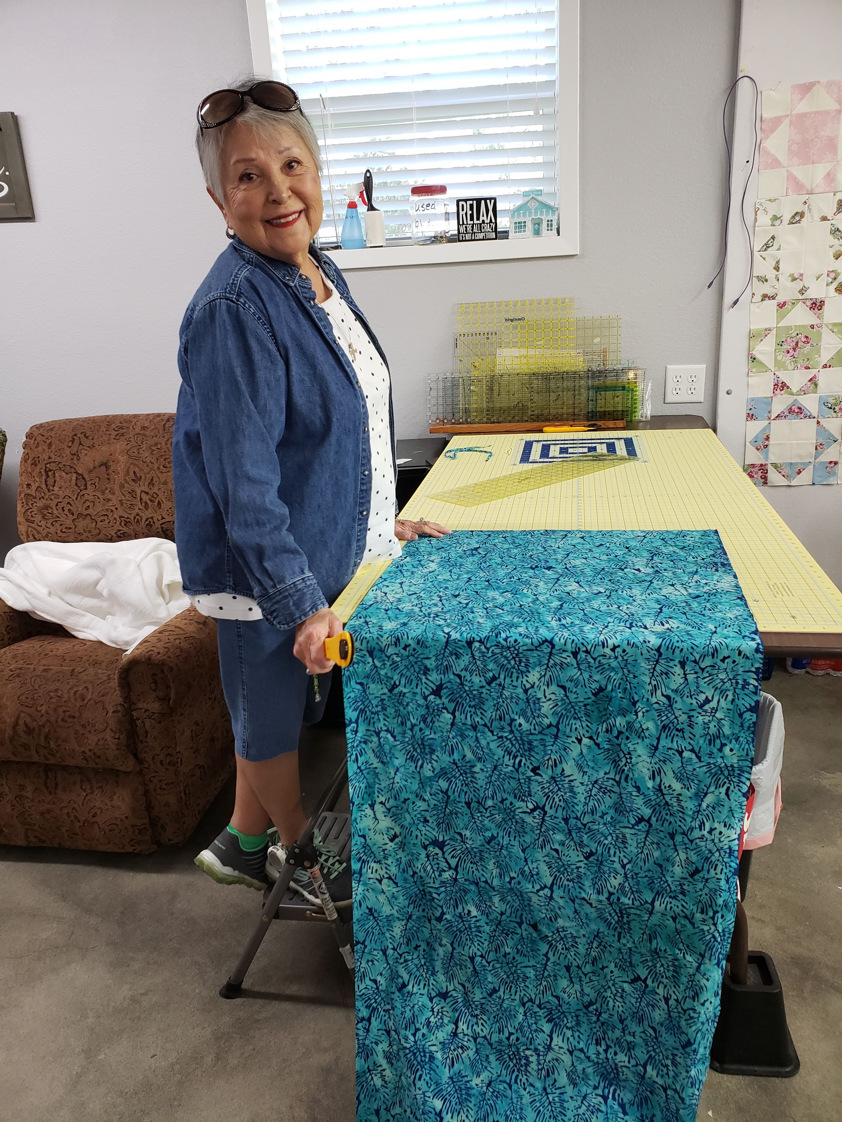 A woman standing next to a table with a blue fabric